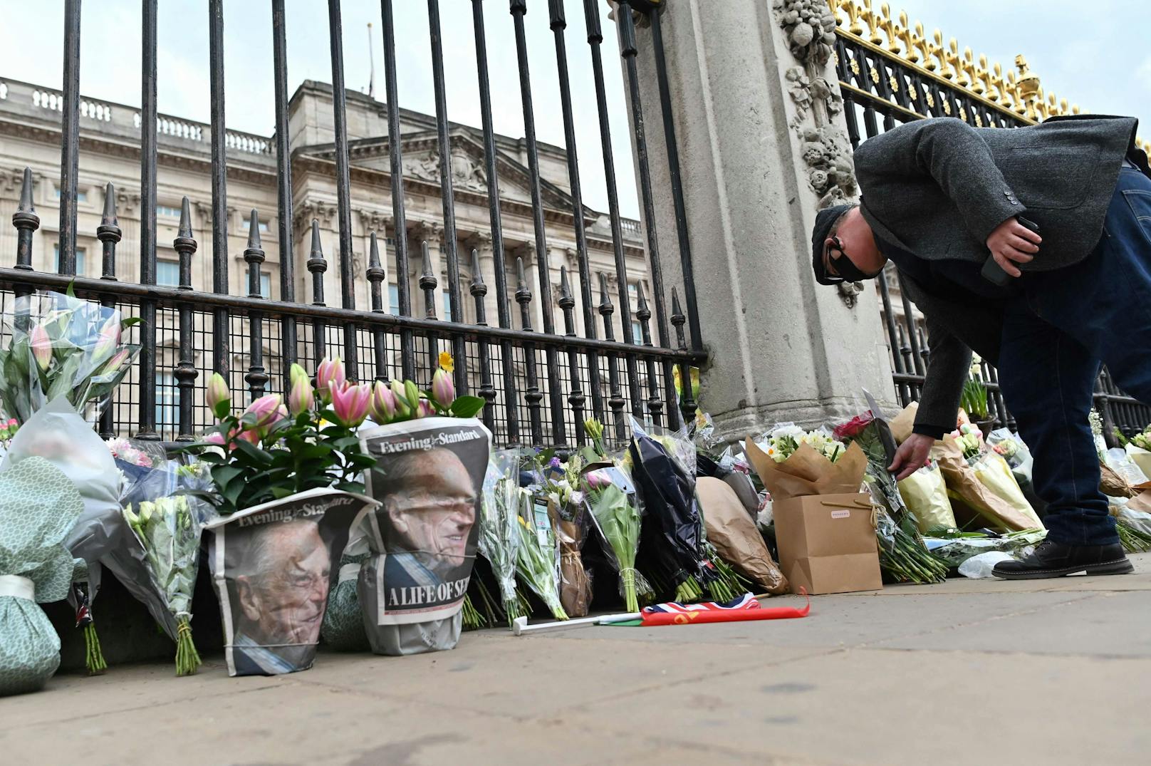 Passanten legen Blumen vor dem Buckingham Palace ab.