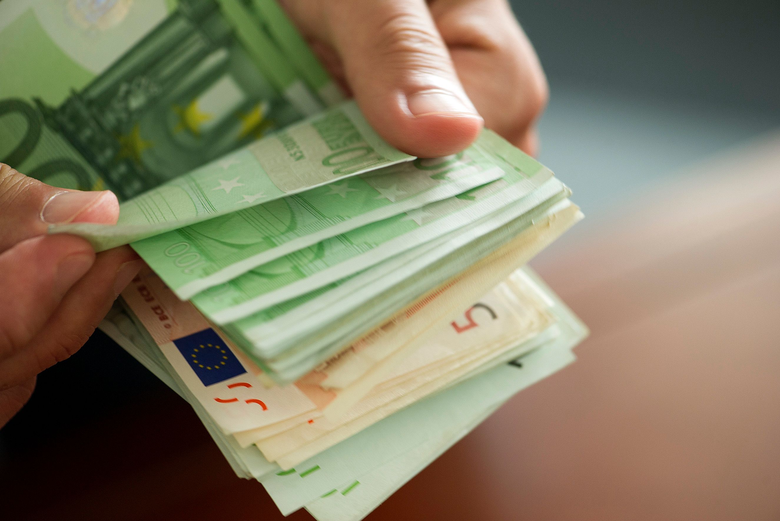 Download von www.picturedesk.com am 10.05.2021 (14:28).  Hands countong stack of money, cropped - 20140731_PD10282 - Rechteinfo: Rights Managed (RM) Model Released