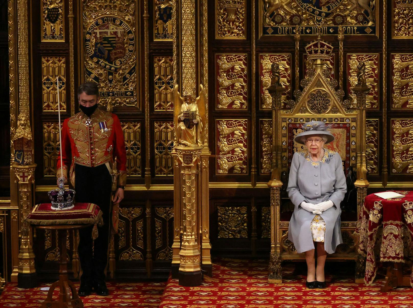 Während Prinz Charles stets rechts der Queen Platz nimmt, befindet sich links die "Imperial State Crown". Schon 2019 verzichtete die Königin auf die Krone und wählte damals ein Diadem. Grund dafür sei ihr Gewicht von etwas mehr als einem Kilogramm gewesen, das der Monarchin mittlerweile etwas zu schwer ist.