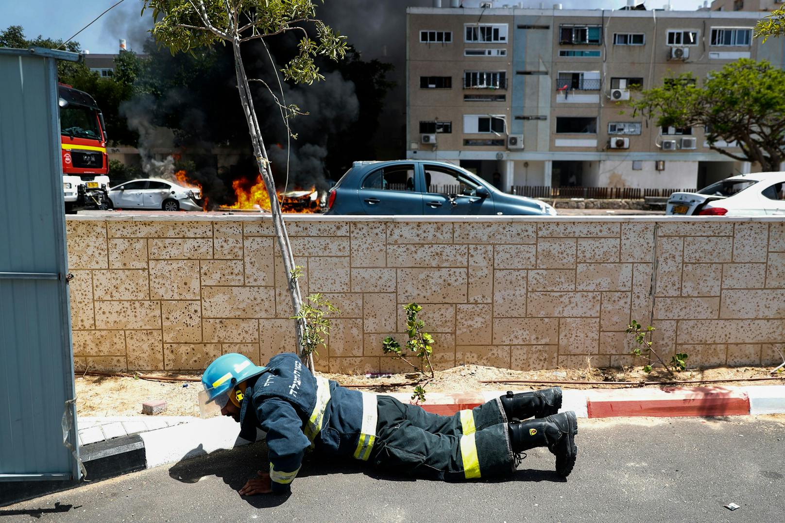 Im Bild: Ein israelischer Feuerwehrmann der vor einem neuerlichen Raketeneinschlag in Deckung geht.
