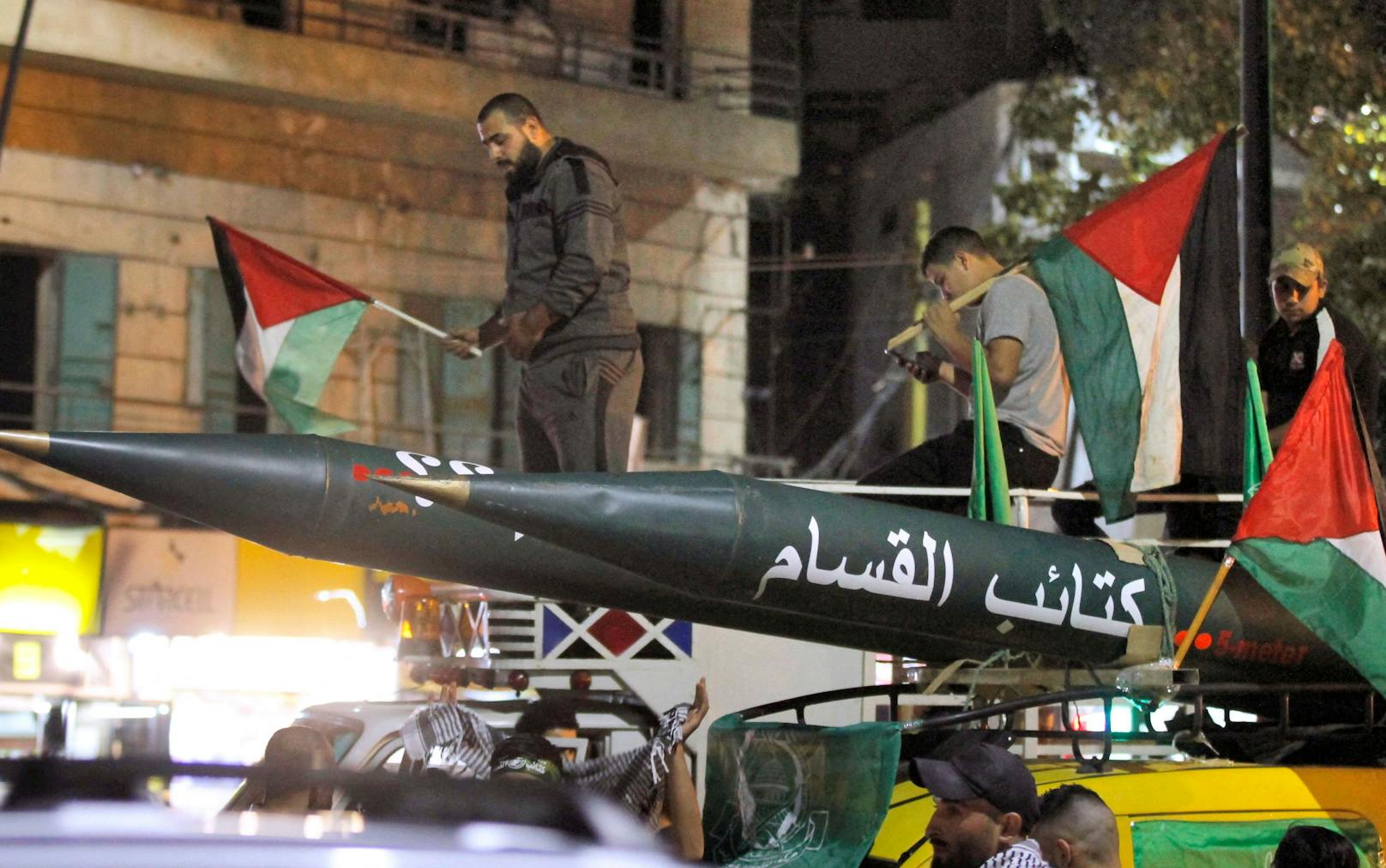 Männer des radikalen Arm der Hamas mit einer der abfeuerten Raketen am 11. Mai 2021.