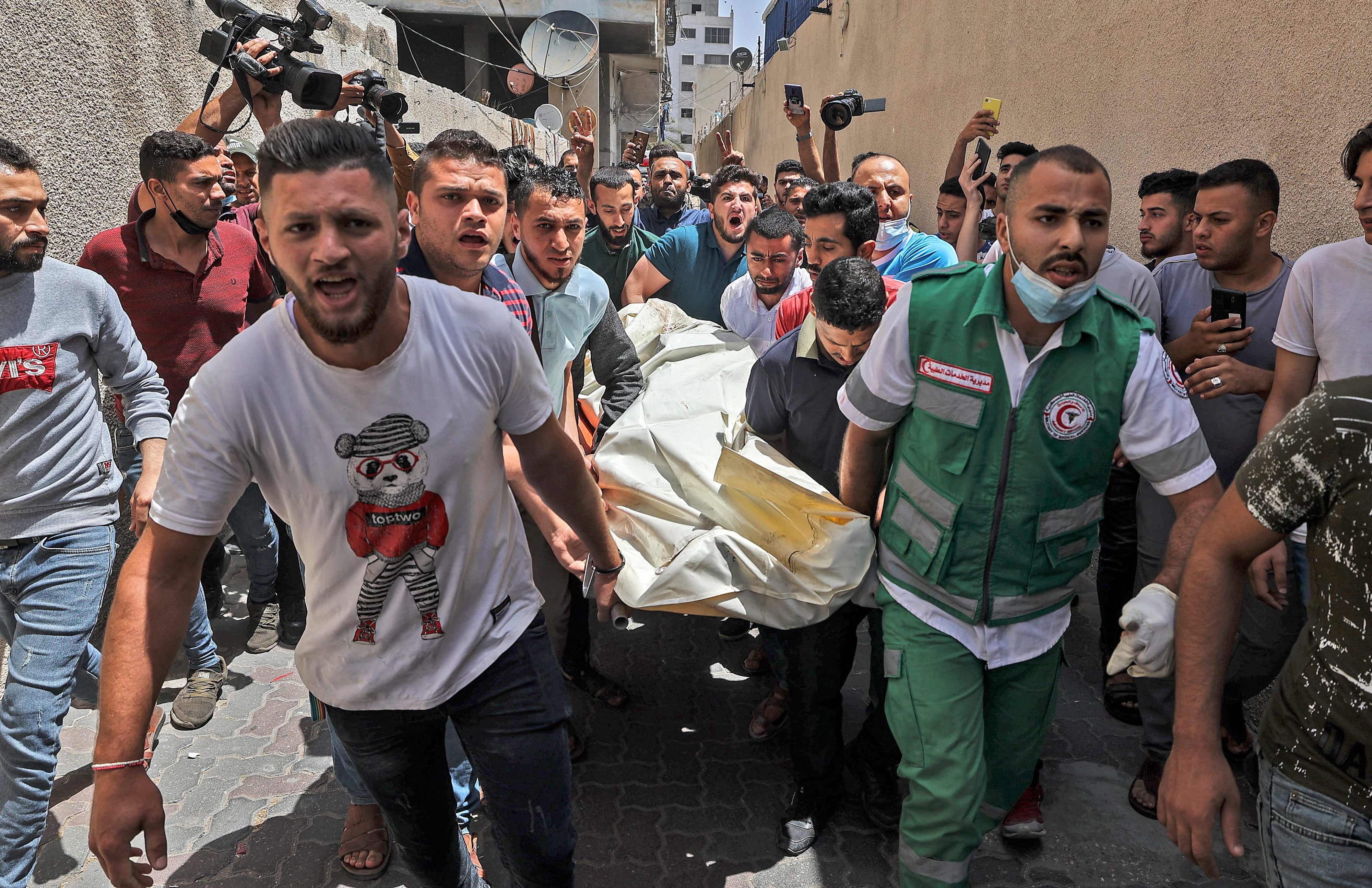 Download von www.picturedesk.com am 12.05.2021 (10:51).  Palestinians evacuate a body from a building targeted by Israeli bombardment in Gaza City on May 11, 2021. - Israel launched deadly air strikes on Gaza in response to a barrage of rockets fired by the Islamist movement Hamas amid spiralling violence sparked by unrest at Jerusalem's Al-Aqsa Mosque compound. (Photo by MAHMUD HAMS / AFP) - 20210511_PD2706 - Rechteinfo: Rights Managed (RM) Nur für redaktionelle Nutzung! Werbliche Nutzung erfordert Freigabe: bitte schicken Sie uns eine Anfrage.