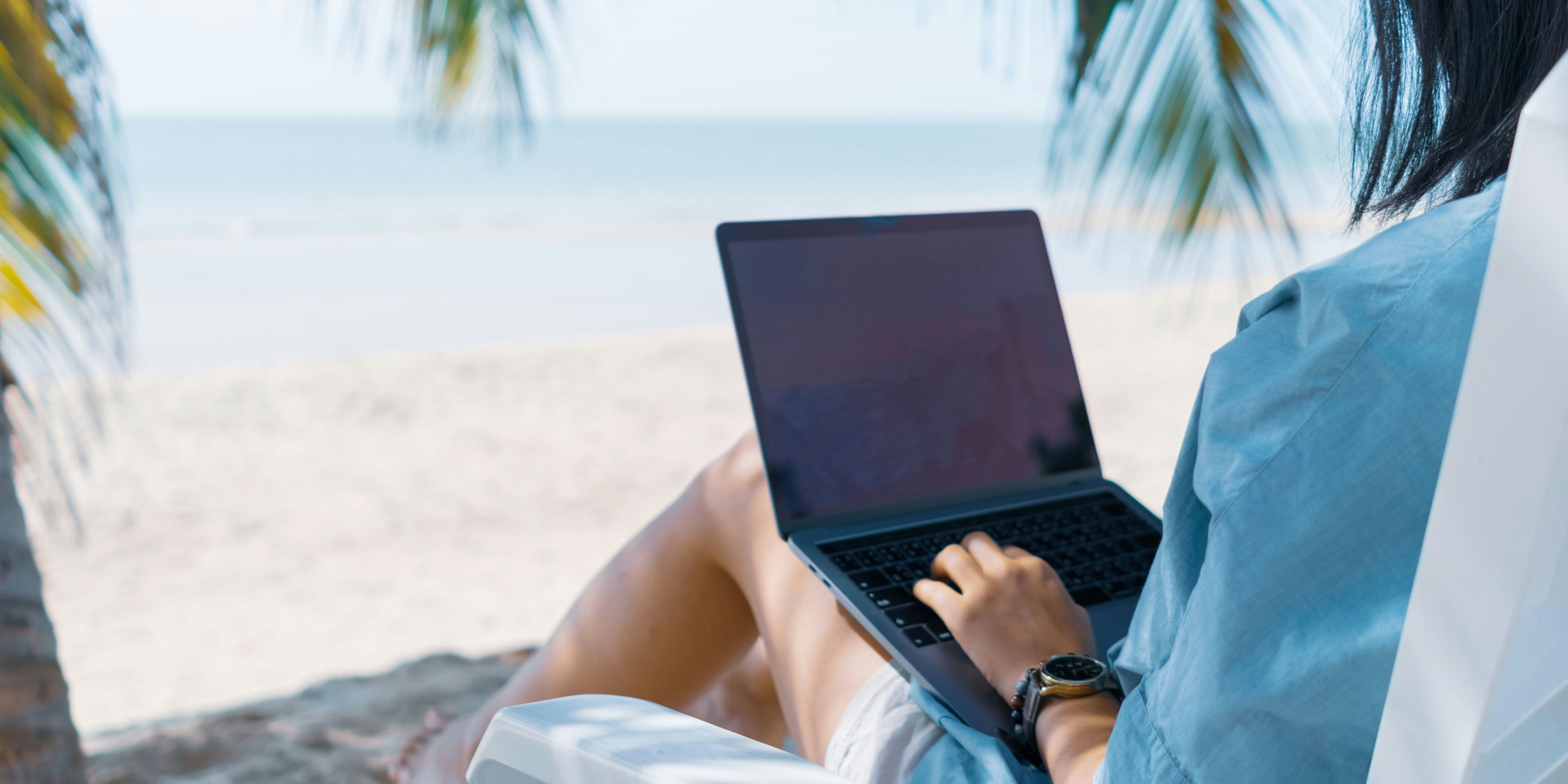 Woman using laptop and smartphone to work study in vacation cady at beach background. Business, financial, trade stock maket and social network concept.