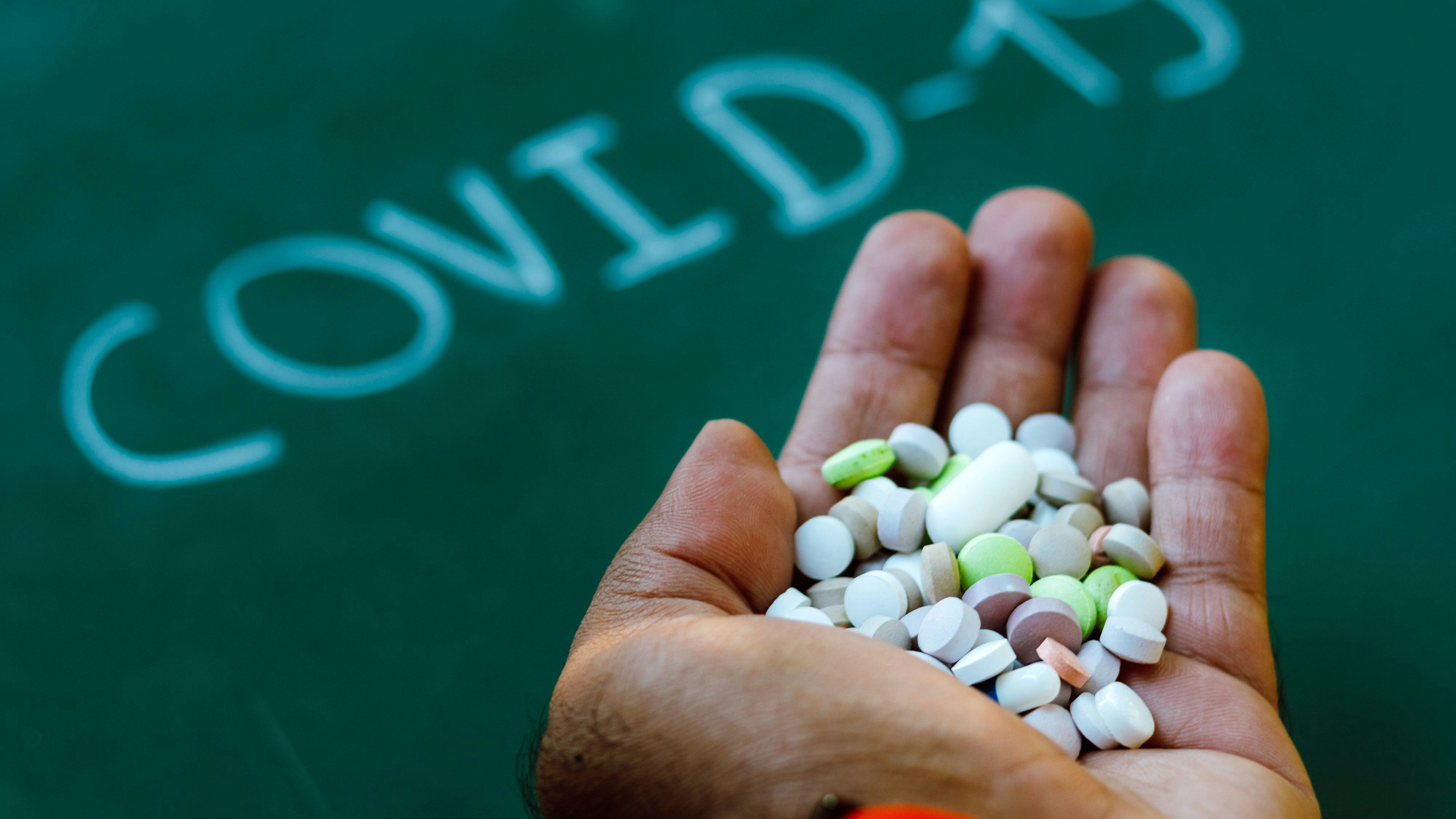 Download von www.picturedesk.com am 17.05.2021 (10:30).  April 10, 2020, Brazil: In this photo illustration a patient's hand holds pharmaceutical pills with a COVID-19 (coronavirus) inscription on the background. - 20200410_PD7823 - Rechteinfo: Rights Managed (RM)