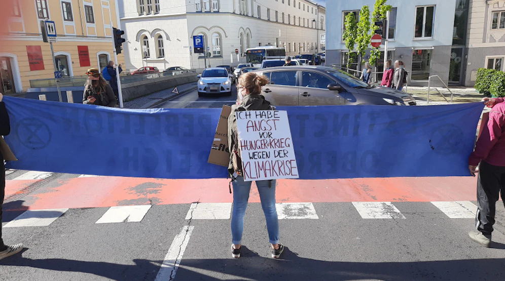 Die drei Demonstranten blockierten die Straße am Pfarrplatz.