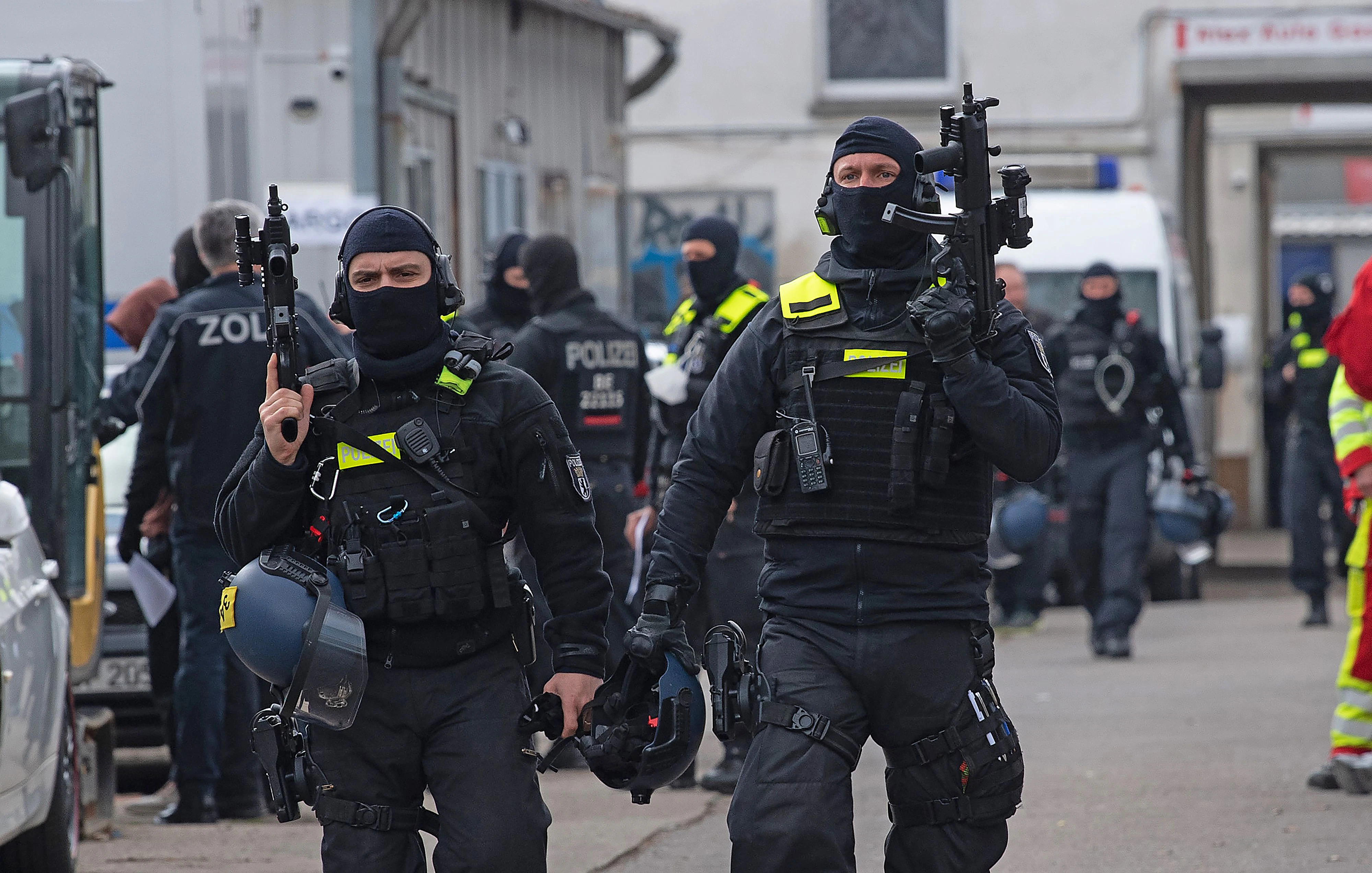 Download von www.picturedesk.com am 19.05.2021 (09:55).  14 April 2021, Berlin: Police officers walk across a compound in Lichtenberg with their weapons in hand. With a raid, the officers take action against suspected, internationally operating drug dealers. Photo: Paul Zinken/dpa-Zentralbild/dpa - 20210414_PD1951 - Rechteinfo: Rights Managed (RM)