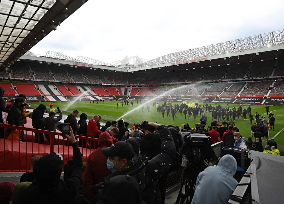 Tausende Manchester-United-Fans protestieren rund um das Old Trafford. Einige verschaffen sich sogar Zugang und stürmen den Rasen.