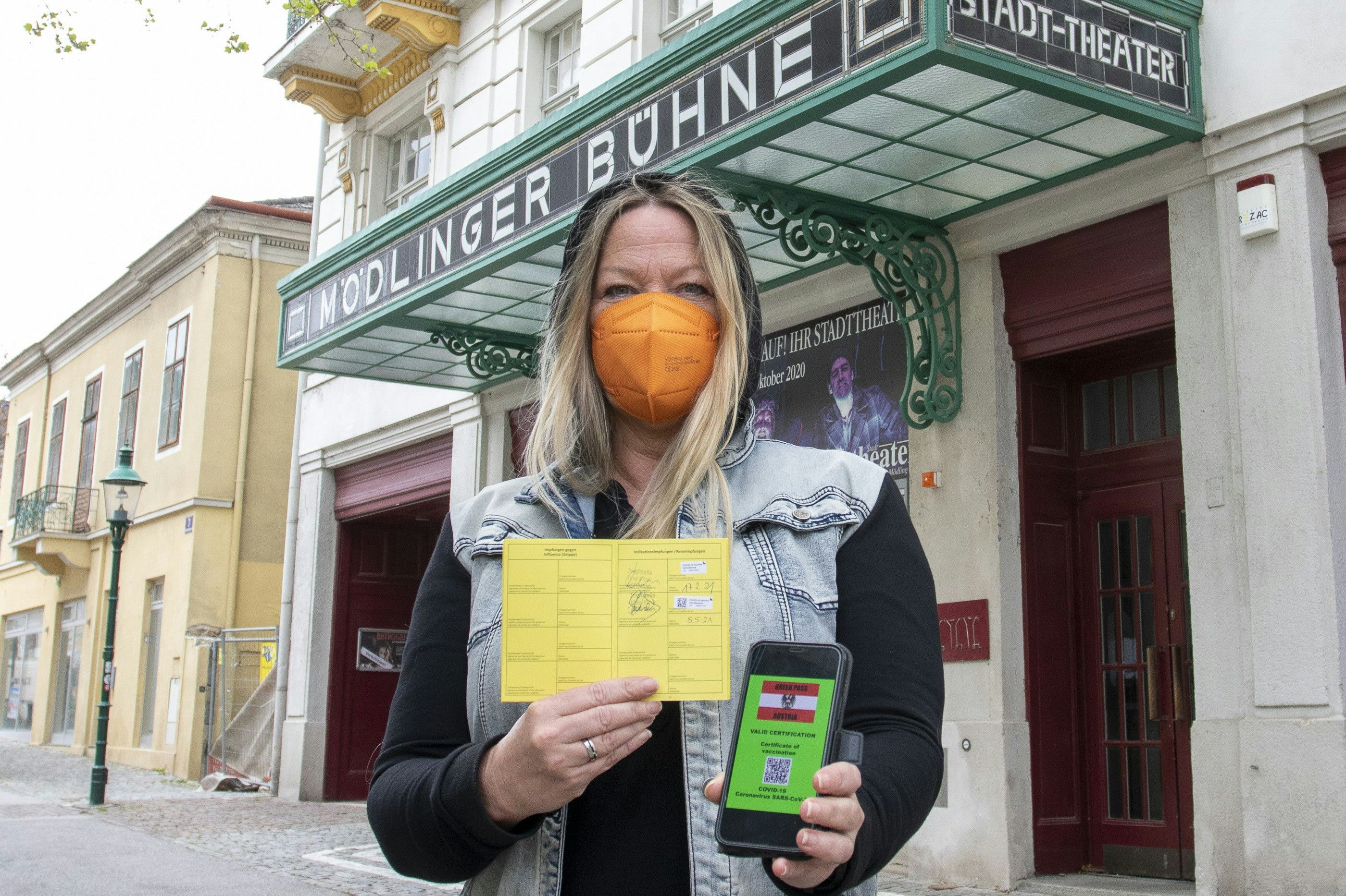 Download von www.picturedesk.com am 20.05.2021 (10:23).  MOEDLING, AUSTRIA - MAY 5: A theater goer with an FFP2 mask, an international vaccination pass with the entries of the 1st and 2nd corona vaccinations, and a mobile phone with a Green Passport from Austria at Stadttheater on May 5, 2021 in Moedling, Austria. 210505_SEPA_13_016 - 20210505_PD7232 - Rechteinfo: Rights Managed (RM)