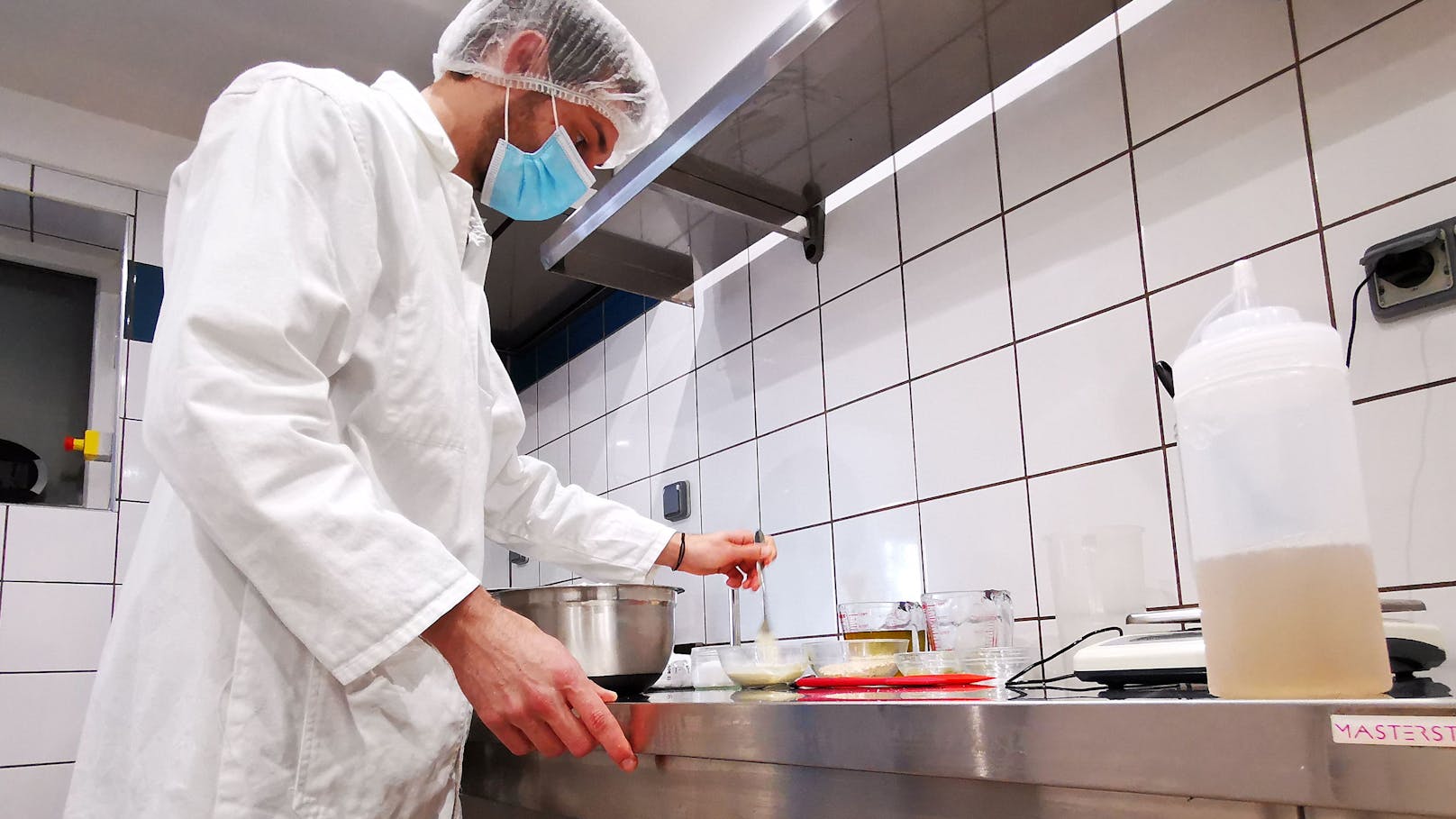 Eine Flasche Schneckenschleim steht auf einem Labortisch, während der französische Schneckenzüchter und Seifenhersteller Damien Desrocher die Zutaten für die Herstellung von Schneckenschleimseife mischt.