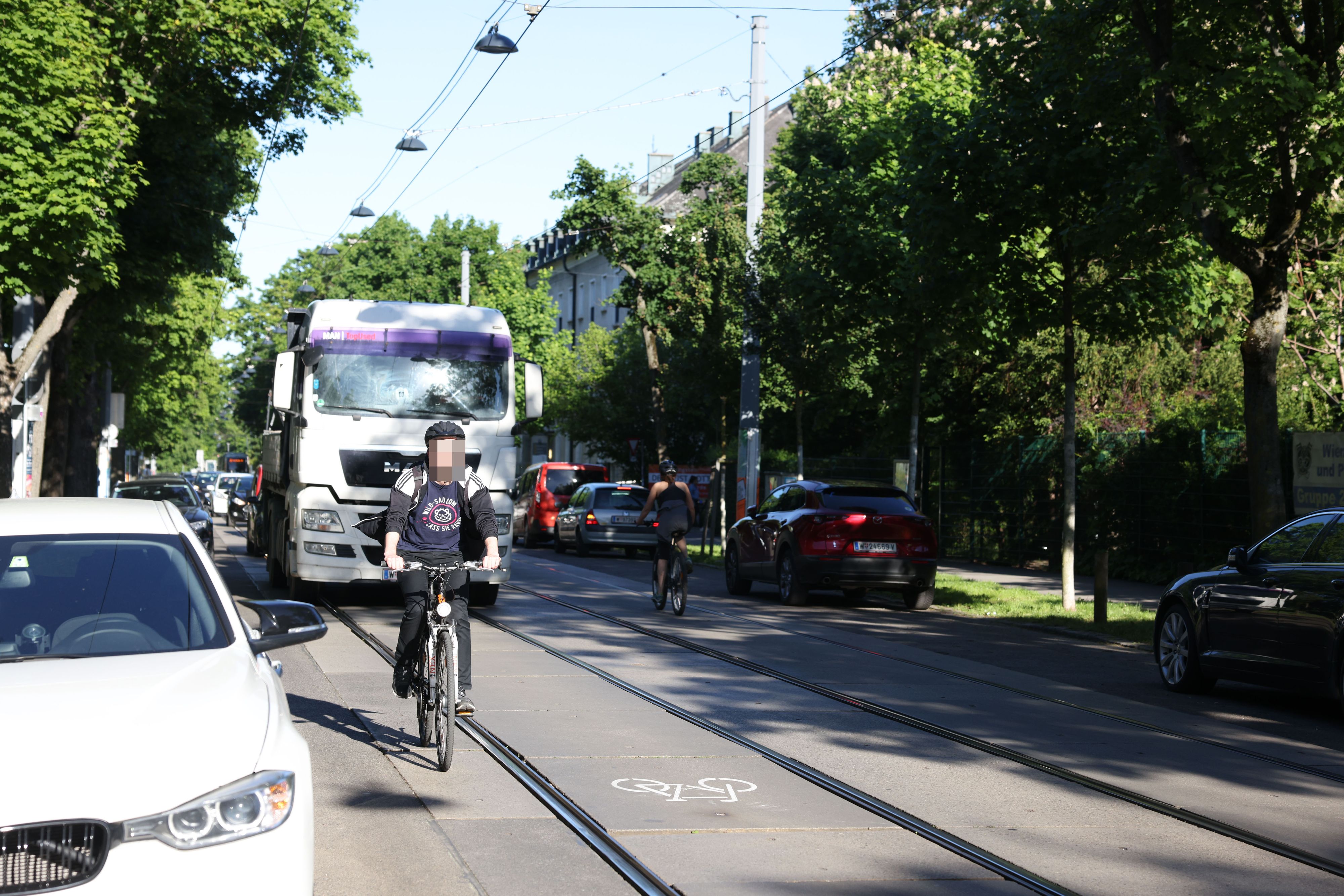 Rad-Piktogramme sollen Radfahrer dazu ermutigen, zwischen den Gleisen zu fahren. Entlang der Autos drohen Dooring-Unfälle.