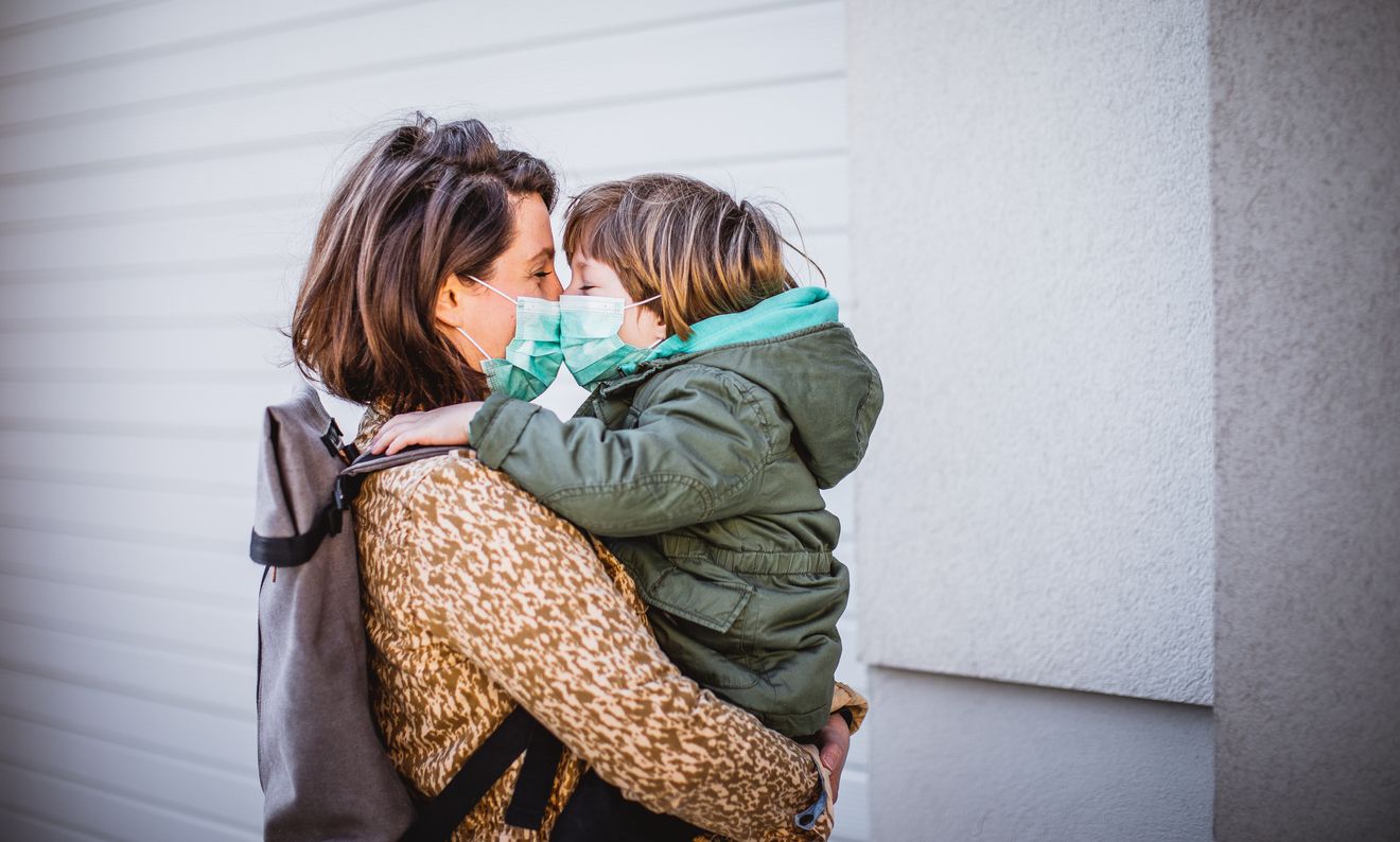 Mother with son on the street wearing protective mask