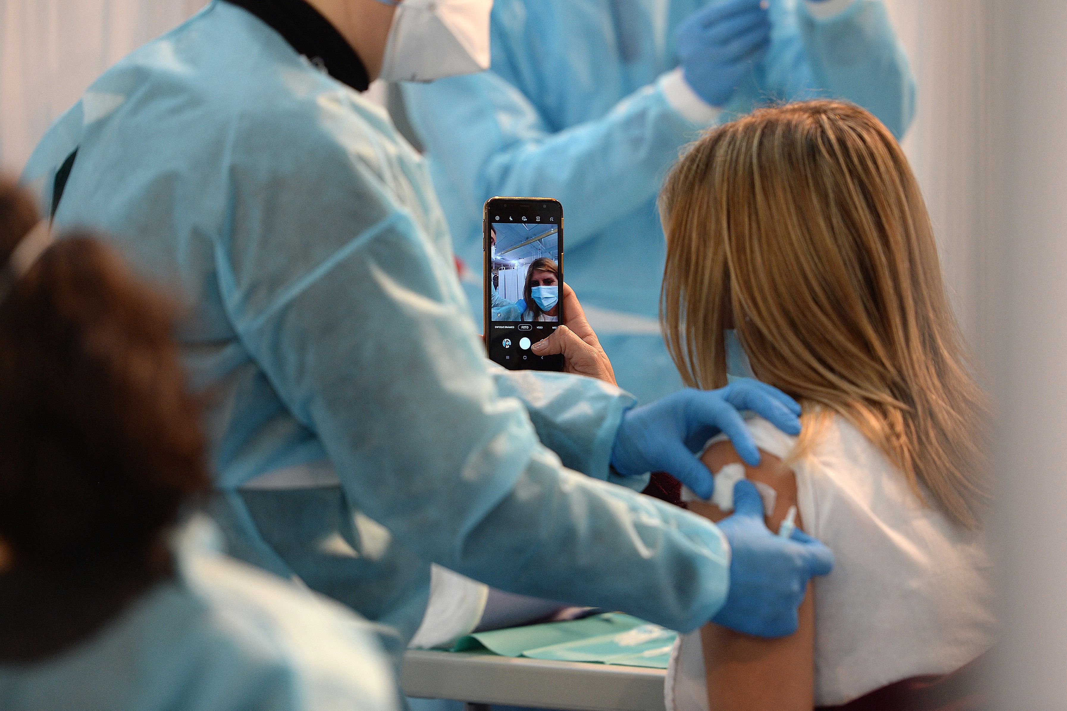 Download von www.picturedesk.com am 04.05.2021 (13:50).  A university teacher takes a selfie as she is vaccinated against Covid-19 during a vaccination campaign at the Sports Centre of the University of Seville in Seville on February 24, 2021. - Spain has been hard-hit by the coronavirus pandemic, recording over 68,000 deaths from more than 3.1 million cases. (Photo by CRISTINA QUICLER / AFP) - 20210224_PD7454 - Rechteinfo: Rights Managed (RM) Nur für redaktionelle Nutzung! Werbliche Nutzung erfordert Freigabe: bitte schicken Sie uns eine Anfrage.