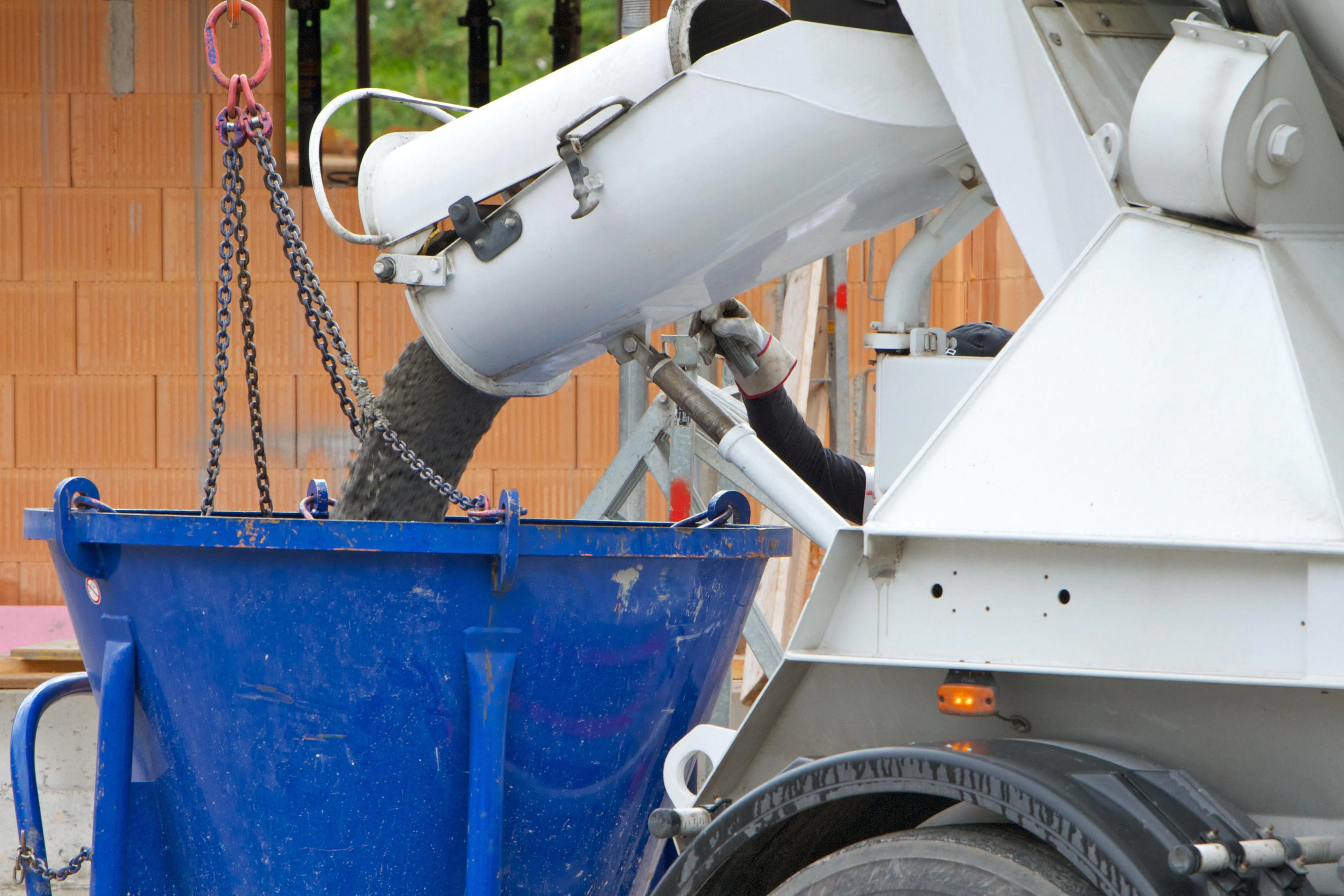 Auf einer Großbaustelle wird Beton aus einem Mischer abgefüllt.