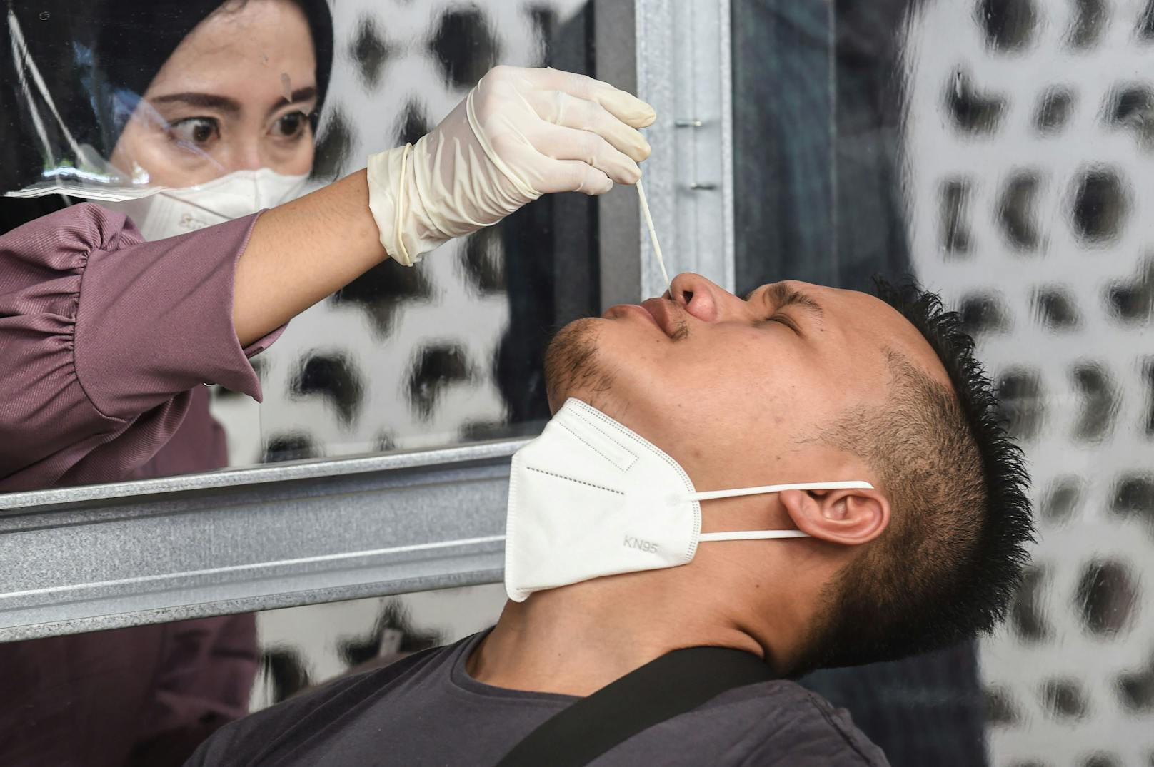 Eine Frau in Indonesien führt einen Nasenabstrich für einen Coronatest durch.