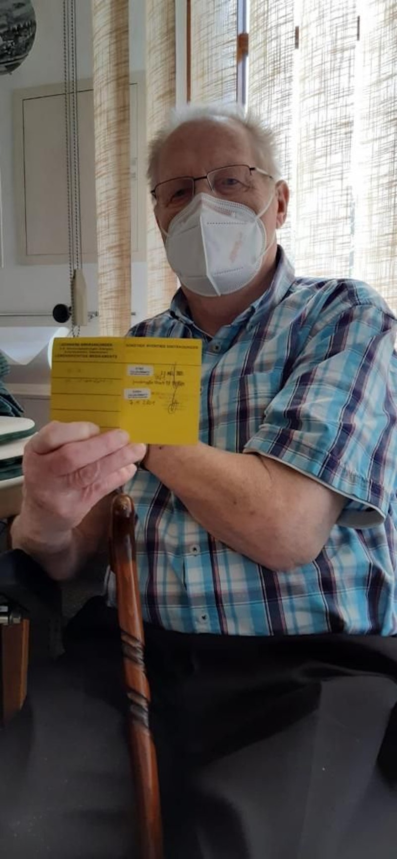 Franz S. (77) zeigt erleichtert seinen Impfpass.