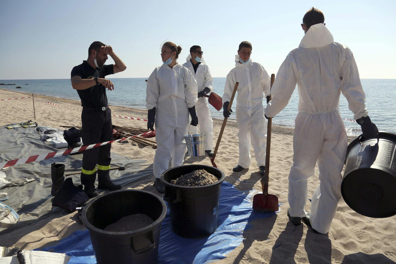 Einsatzkräfte reinigen Strand und Meer von einer Verseuchung durch mutmaßlich illegal abgelassenes Öl vor der Küste von Korsika (14. Juni 2021).