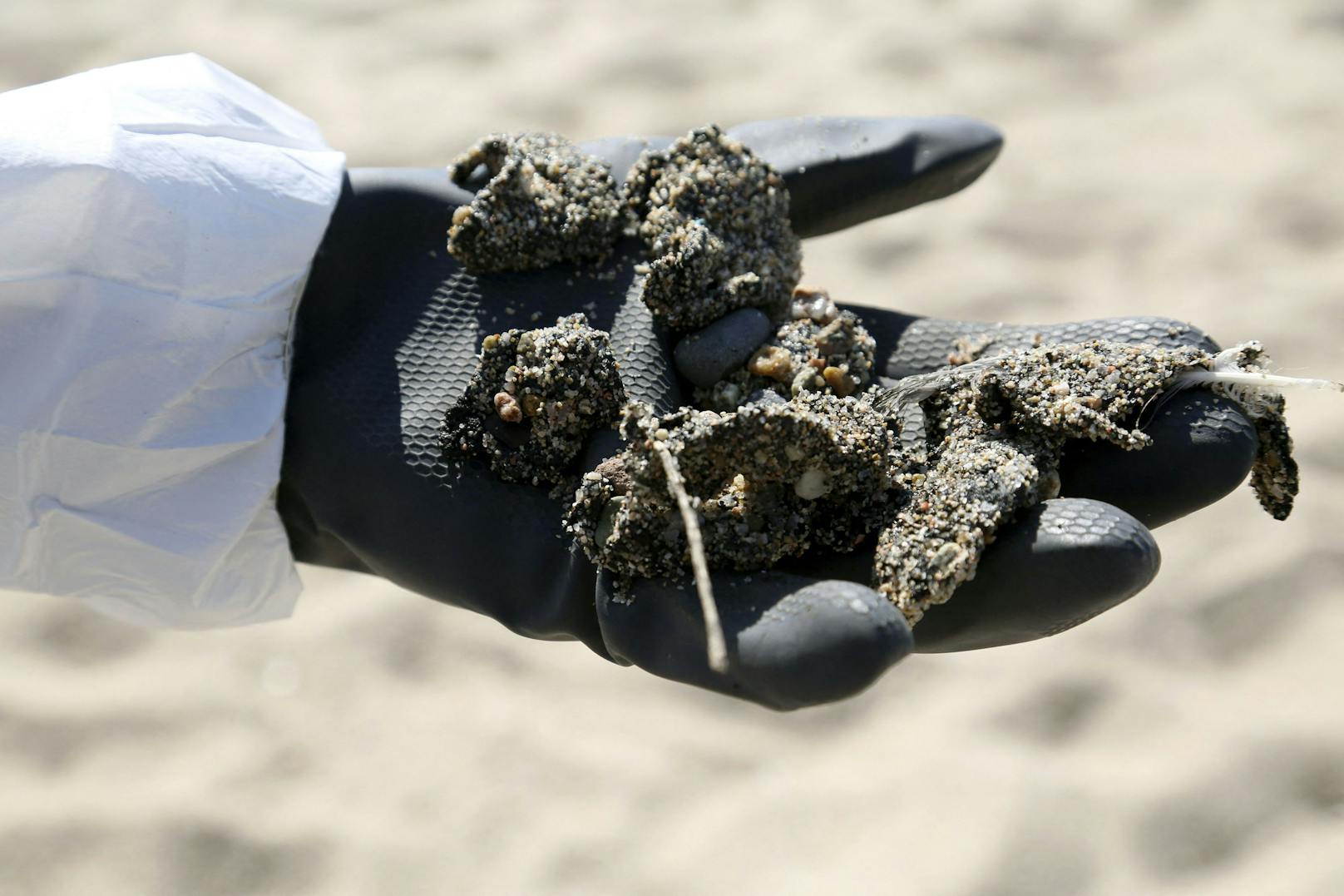 Einsatzkräfte reinigen Strand und Meer von einer Verseuchung durch mutmaßlich illegal abgelassenes Öl vor der Küste von Korsika (14. Juni 2021).