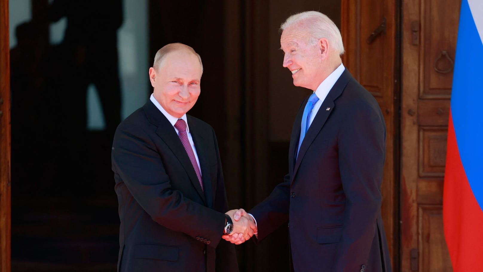 Russlands Präsident Wladimir Putin und US-Präsident Joe Biden reichen einander die Hände.