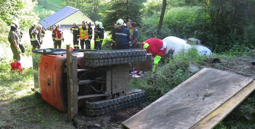 Die Einsatzkräfte beim umgekippten Bagger.