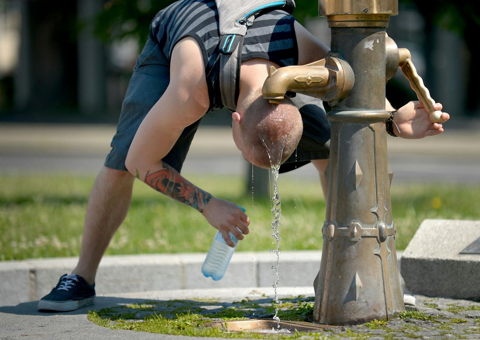 Ein junger Mann kühlt seinen Kopf unter einen Hydranten in Wien. Für das Wochenende werden in Österreich tropische Temperaturen über 35 Grad Celsius erwartet.