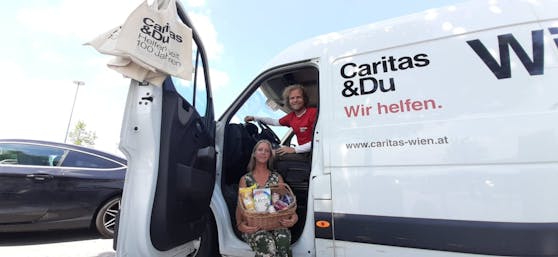 Tamara und Niko stehen mit dem "Wir helfen"-Bus bei der SCS in Vösendorf.