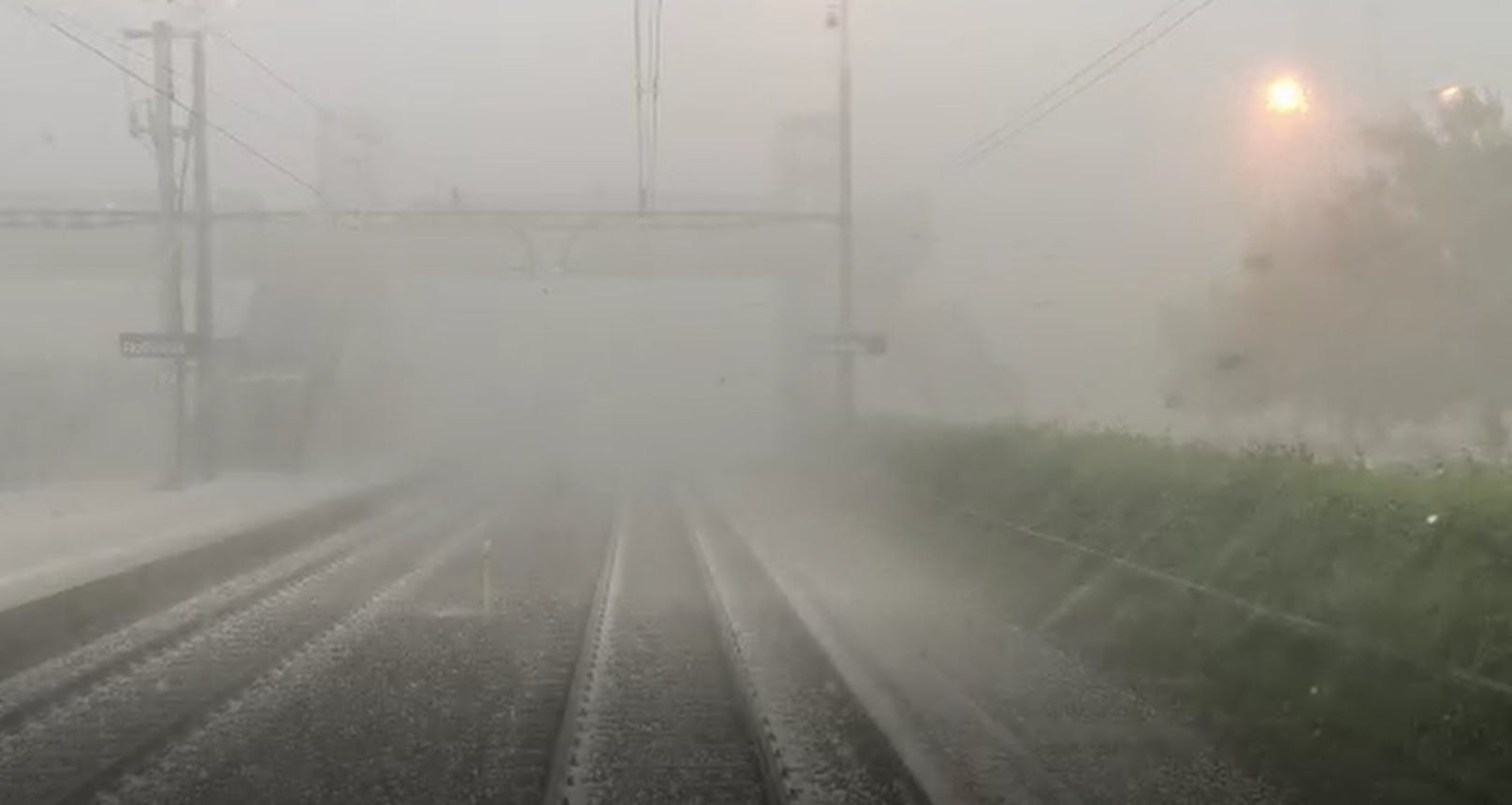 Lokführer filmt, wie Regen und Hagel gegen seinen Zug peitschen.