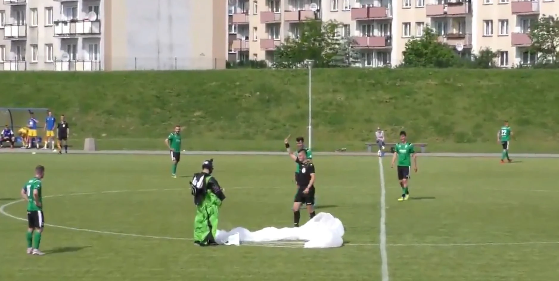 Ein Paragleiter landet mitten auf dem Fußballplatz. 