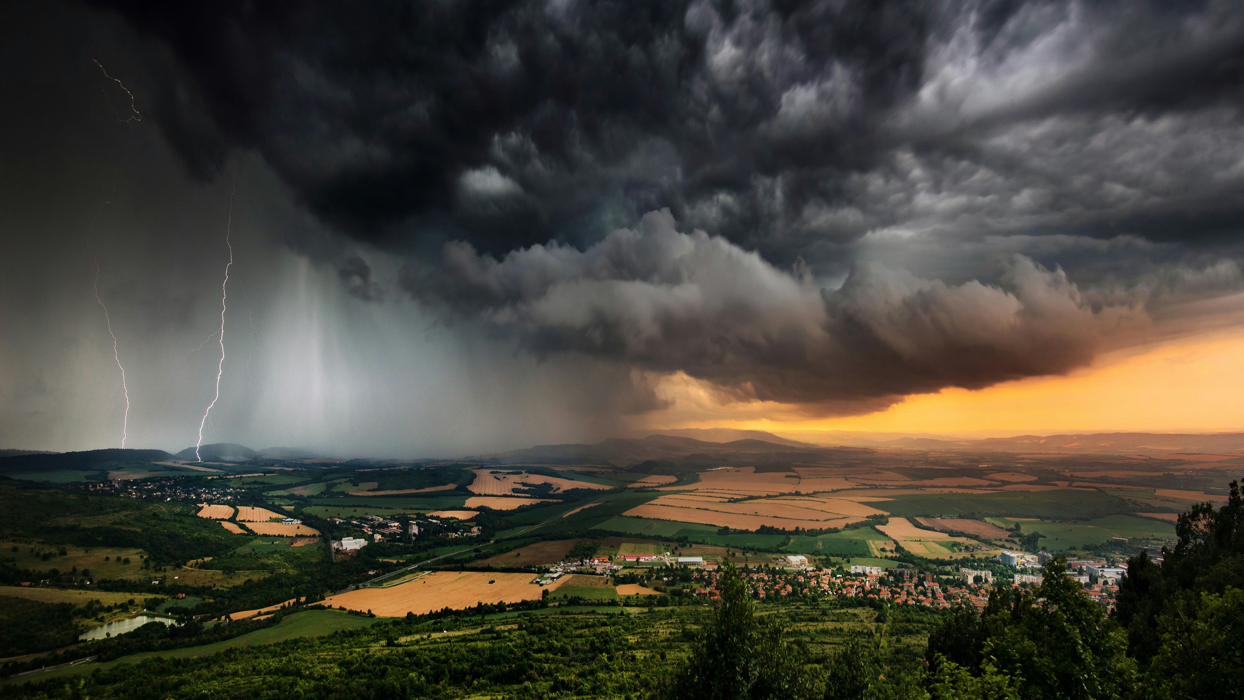 A severe thunderstorm shelf cloud races across the country side on a summer afternoon