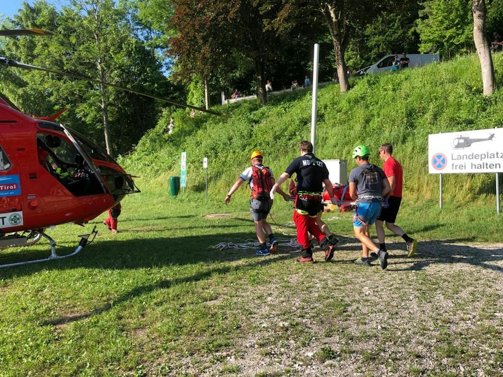 Bergretter bringen die Verletzte zum Hubschrauber.