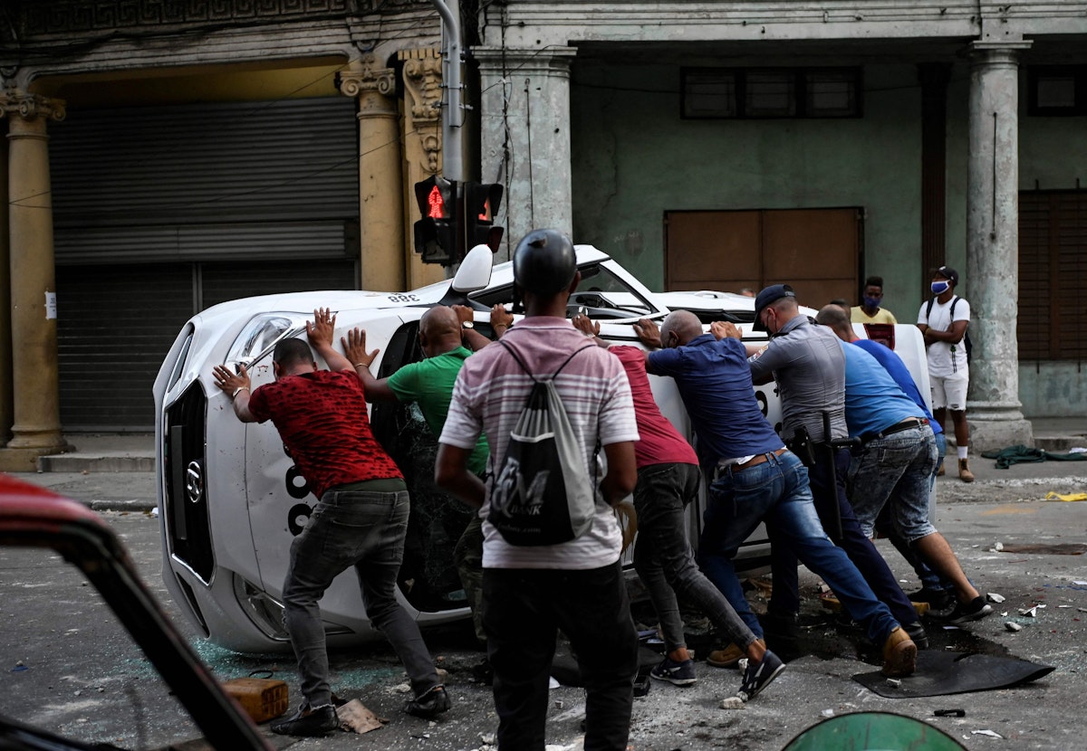 Download von www.picturedesk.com am 12.07.2021 (12:51).  TOPSHOT - People push an overturned car in the street in the framework of a demonstration against Cuban President Miguel Diaz-Canel in Havana, on July 11, 2021. - Thousands of Cubans took part in rare protests Sunday against the communist government, marching through a town chanting "Down with the dictatorship" and "We want liberty." (Photo by YAMIL LAGE / AFP) - 20210711_PD17066 - Rechteinfo: Rights Managed (RM) Nur für redaktionelle Nutzung! Werbliche Nutzung erfordert Freigabe: bitte schicken Sie uns eine Anfrage.
