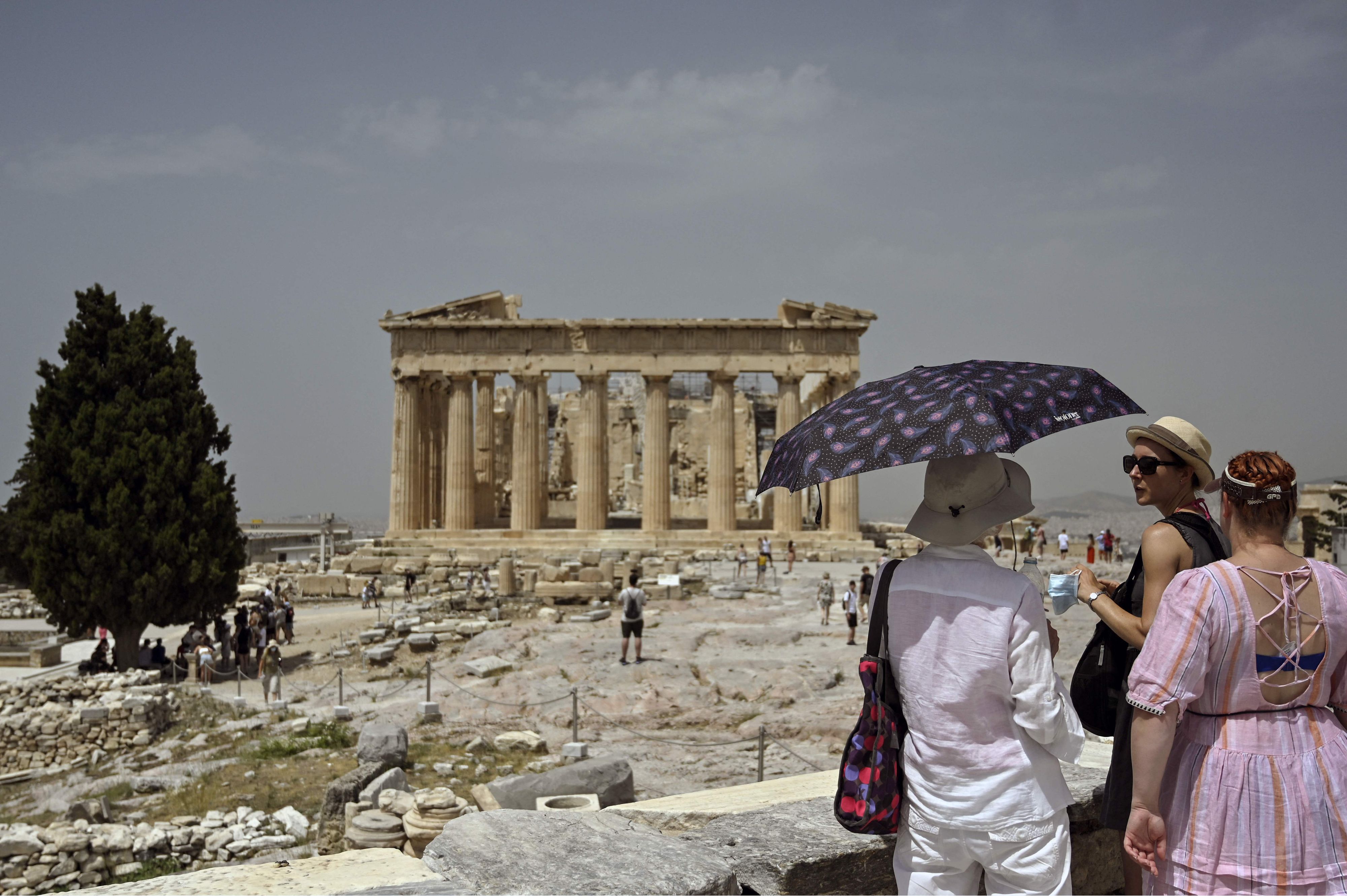 Download von www.picturedesk.com am 14.07.2021 (14:08).  A tourist holds a parasol as she visits the Ancient Acropolis archeological site in Athens on July 1, 2021. - The archaeological sites are closed on July 1 during the hottest hours as Greece is bracing for the first heatwave of the summer as a heat wave rolls into the country, pushing daytime temperatures into 40+ Celsius territory in many parts of the country. (Photo by Louisa GOULIAMAKI / X07402 / AFP) - 20210701_PD3017 - Rechteinfo: Rights Managed (RM) Nur für redaktionelle Nutzung! Werbliche Nutzung erfordert Freigabe: bitte schicken Sie uns eine Anfrage.