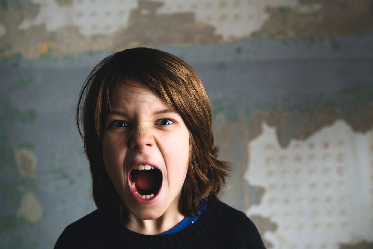 Boy screaming and looking at camera