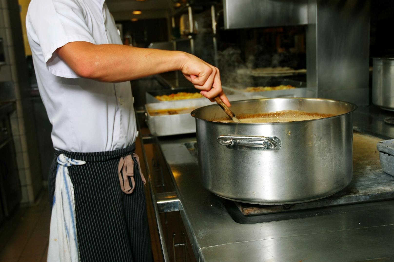 Ein Koch beim Zubereiten einer Suppe in einer Restaurantküche. Symbolfoto