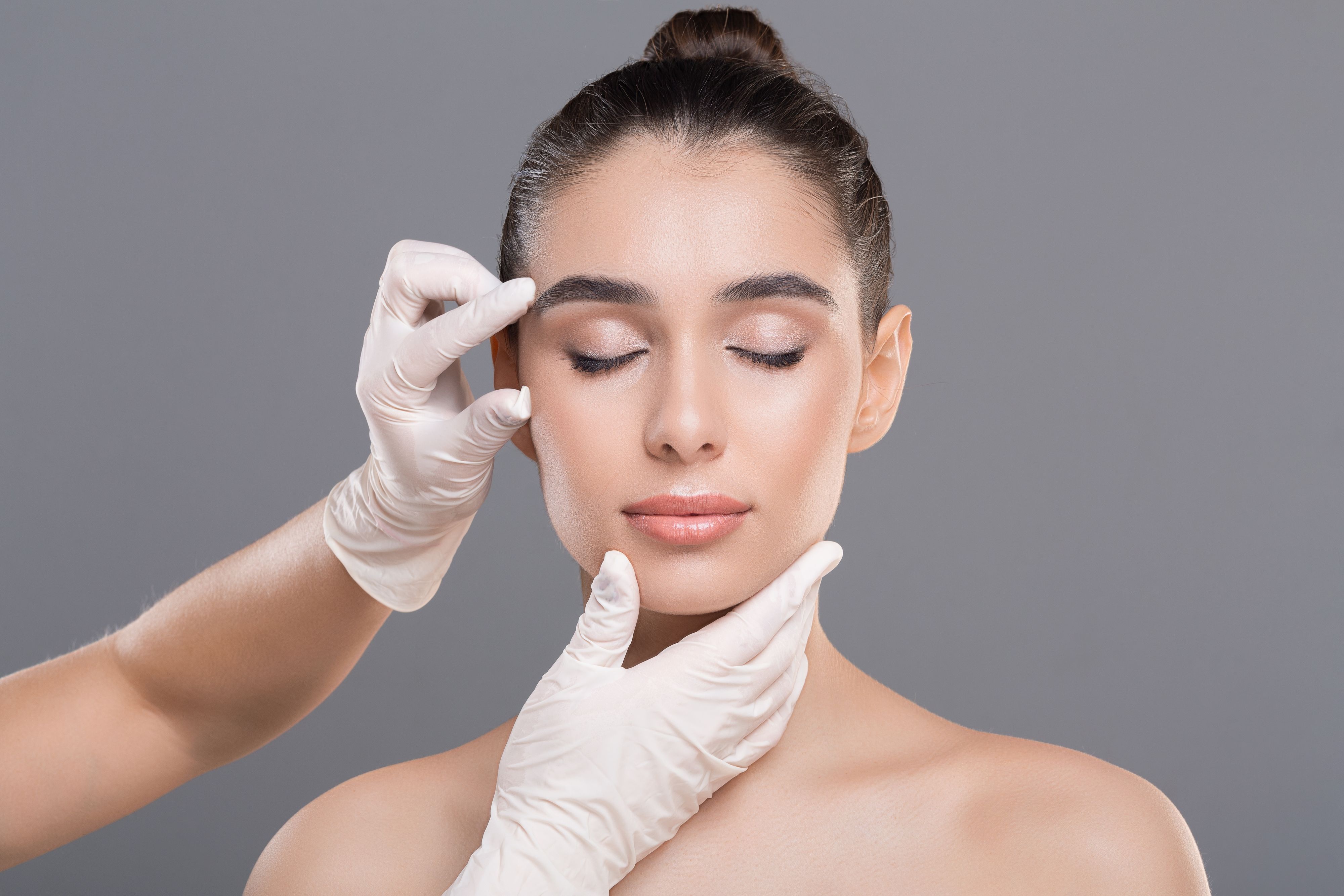 Youth and beauty treatment. Cosmetologist examining facial wrinkles on young woman face