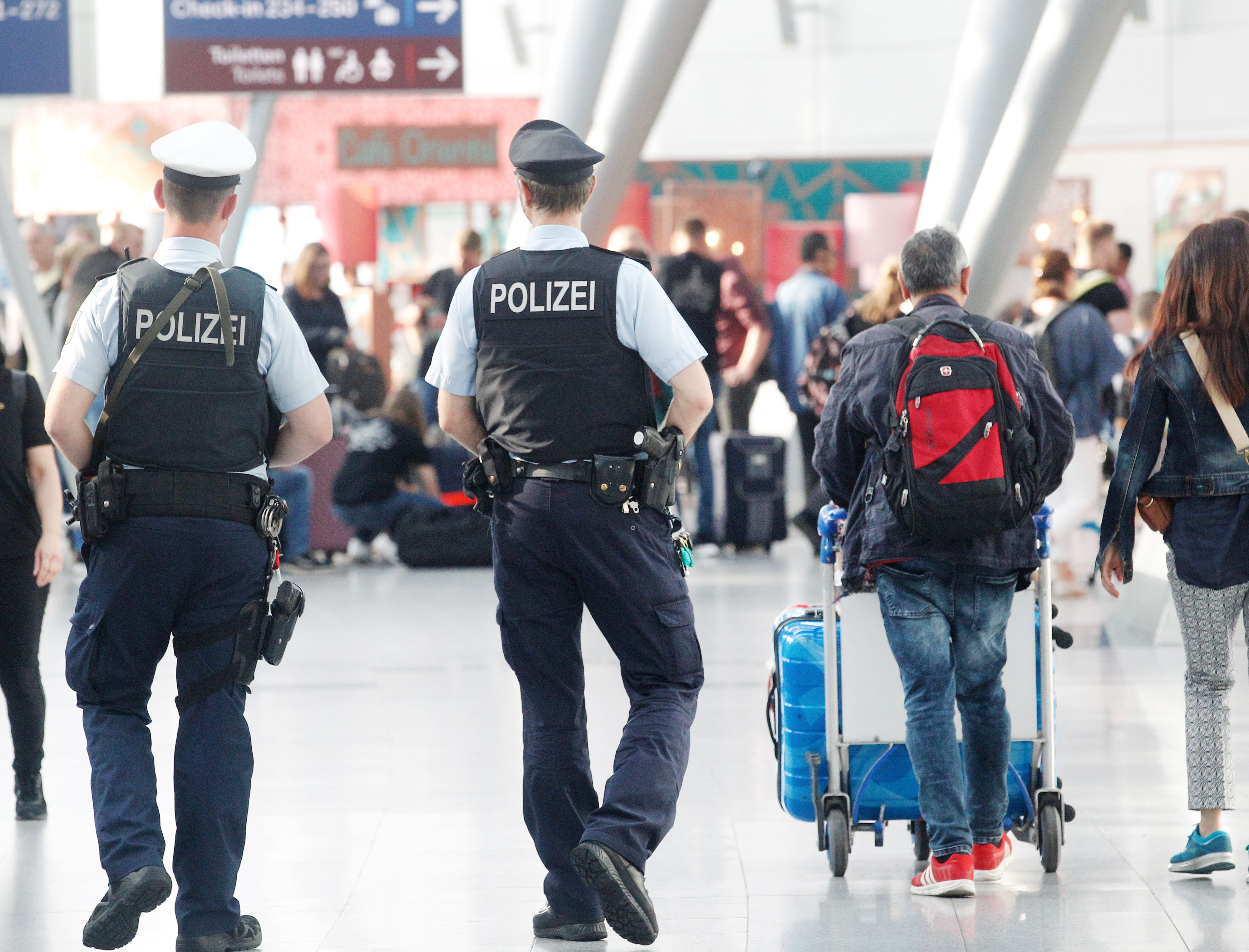 Download von www.picturedesk.com am 06.07.2021 (14:04).  12 July 2019, North Rhine-Westphalia, Duesseldorf: CORRECTS CAPTURE PLACE - Cops walk through the departure lounge at the airport. Summer holidays begin in North Rhine-Westphalia. Directly on the last school day the travel wave starts, many families start into the vacation. Photo: Roland Weihrauch/dpa - 20190712_PD1057 - Rechteinfo: Rights Managed (RM)
