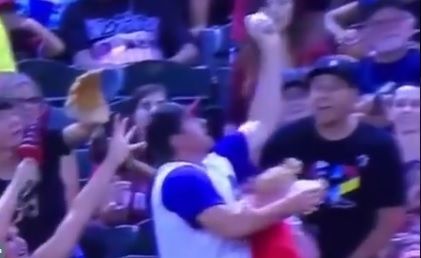 Im Moment, als der Vater den Ball fängt, rutscht das Mädchen in Richtung Boden.