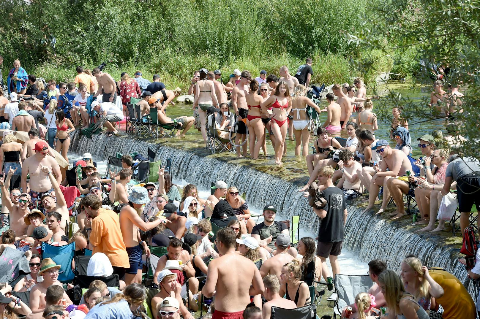 Festivalbesucher kühlen sich bei sommerlichen Temperaturen im Rahmen des Frequency-Festivals traditionell in der kalten Traisen ab.