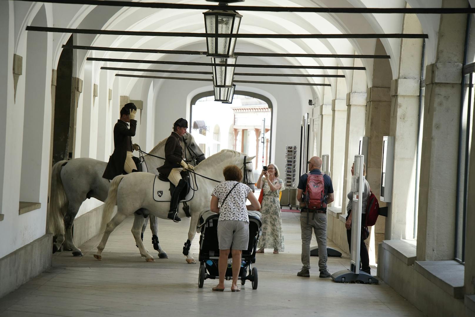 Auf dem Weg aus dem Stall lüften die Reiter ihre Hüte und grüßen die Schaulustigen.