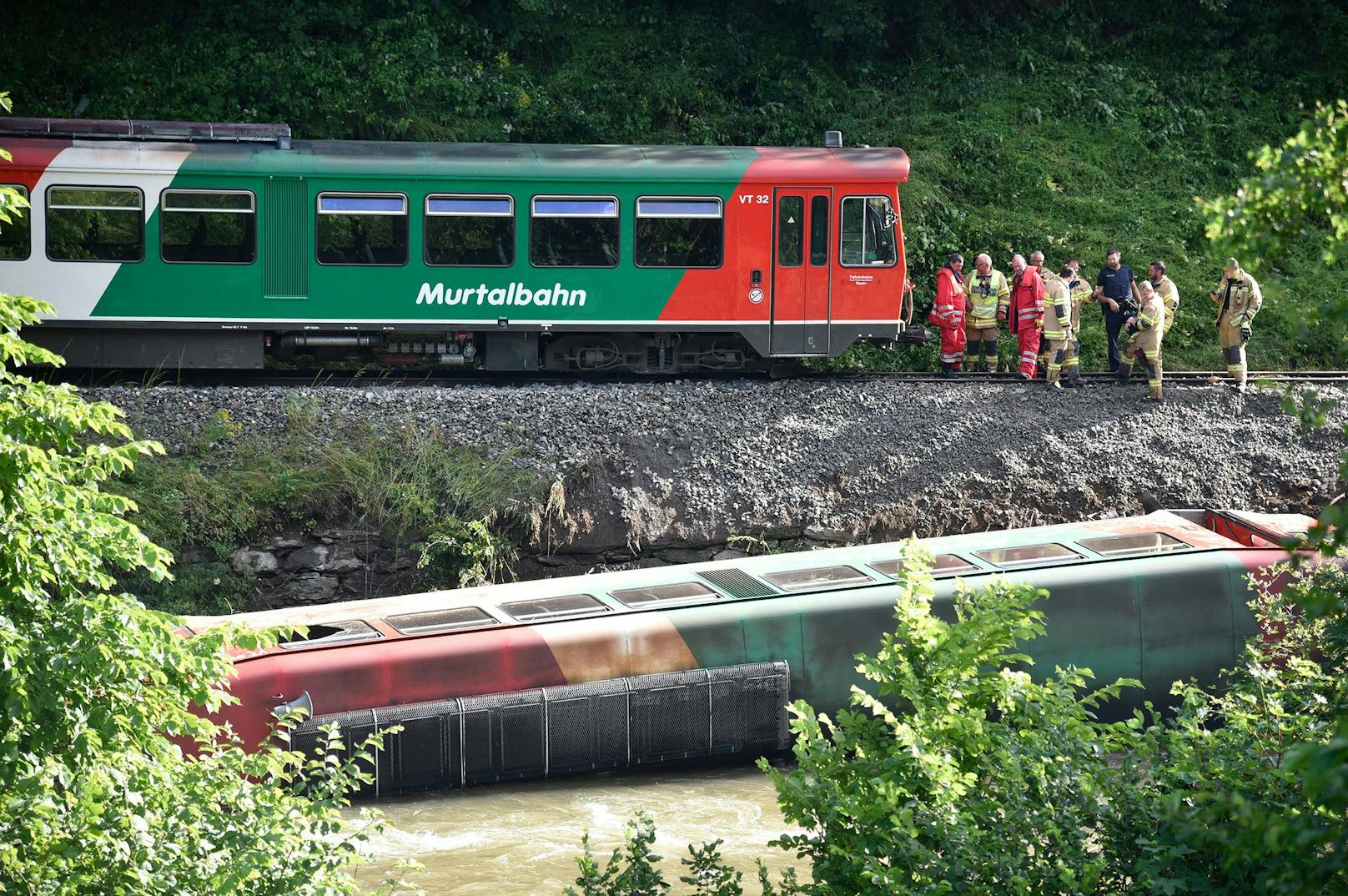 Nachdem die Passagiere gerettet und die Verletzten versorgt wurden, wird am Vormittag versucht, den umgestürzten Waggon aus dem Fluss zu heben.