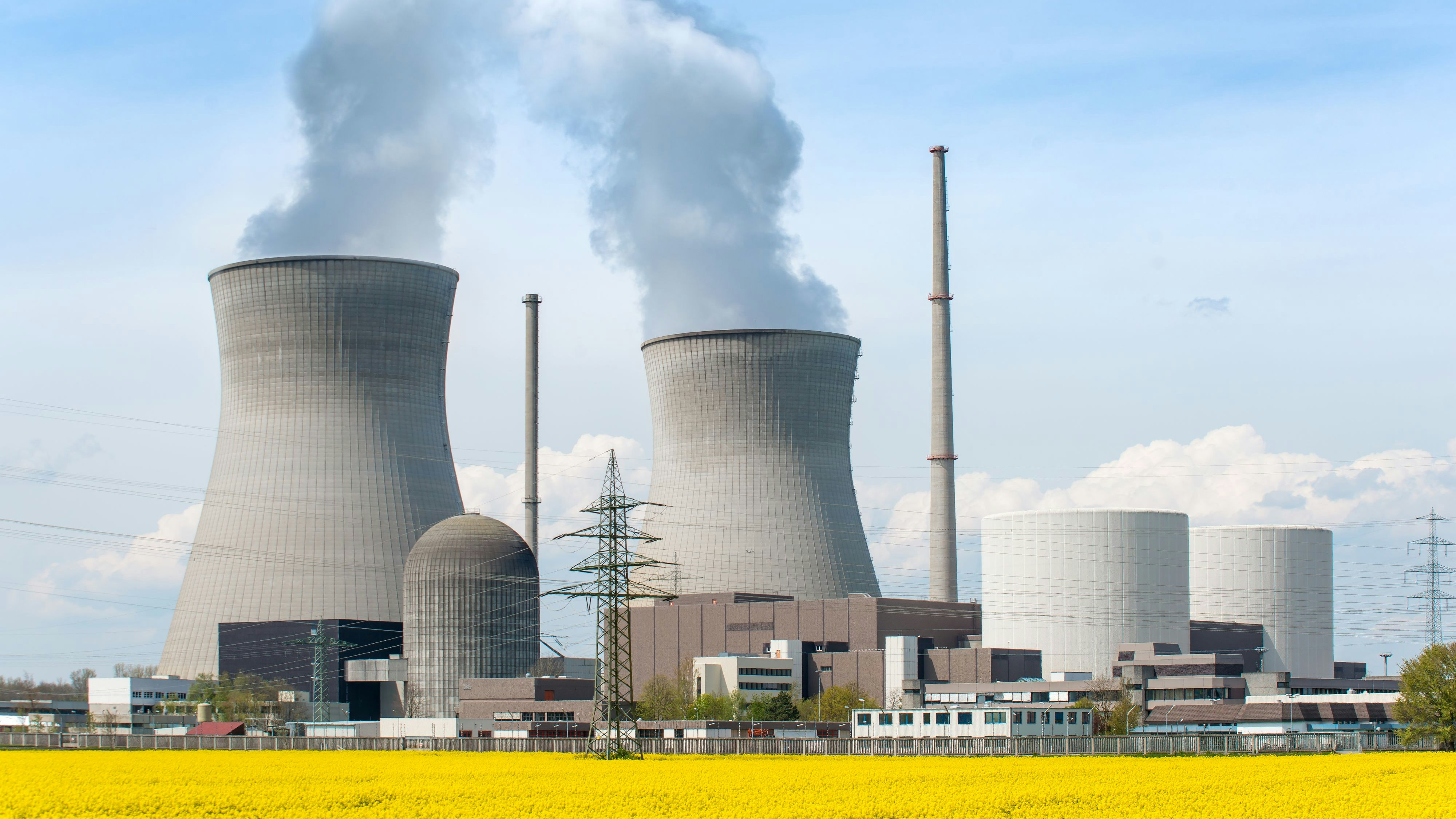 Nuclear power Energy concept - Nuclear power plant with yellow field and big blue clouds. Nuclear power plant in Germany
