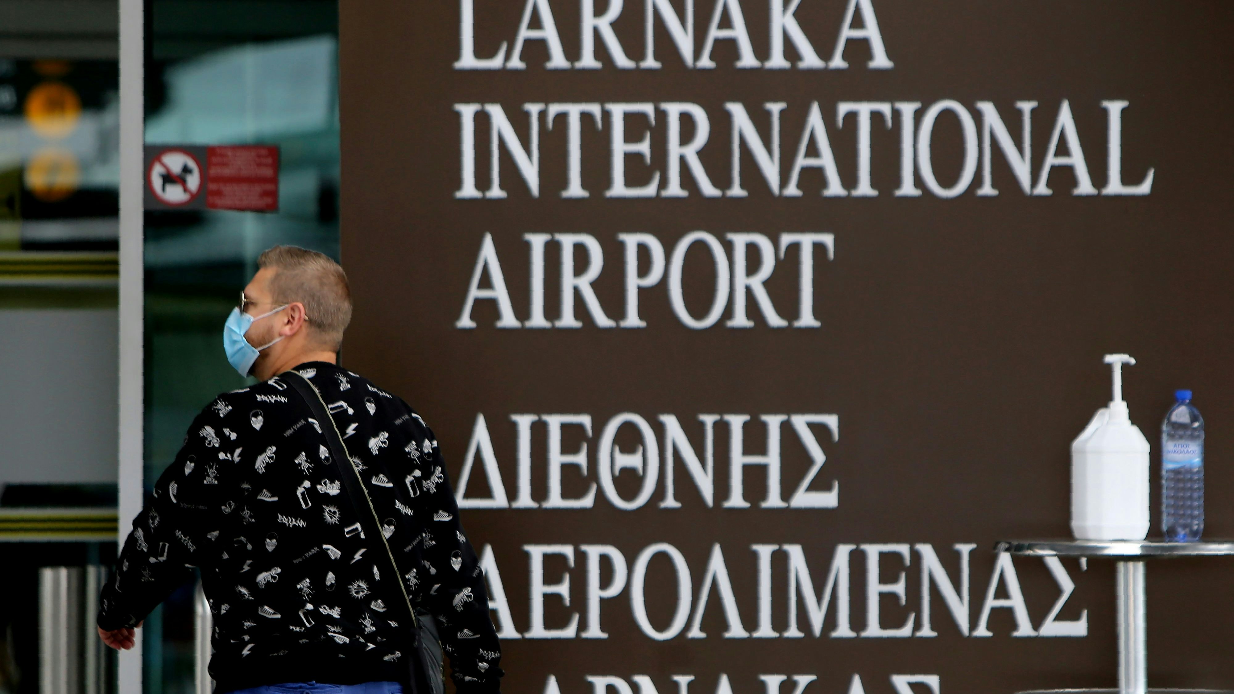 Download von www.picturedesk.com am 03.01.2022 (13:58).  A traveler wearing a face mask enters form a main gate of Cyprus' main international airport in Larnaca on Wednesday, March 18, 2020. As part of additional measures to prevent the spread of the new coronavirus, Cyprus' government announced late Tuesday a 14-day ban on all inbound flights from 28 countries including the U.K., Russia, the Netherlands, Greece, Israel, Belgium, Germany and Egypt. (AP Photo/Petros Karadjias) - 20200318_PD5431 - Rechteinfo: Rights Managed (RM)