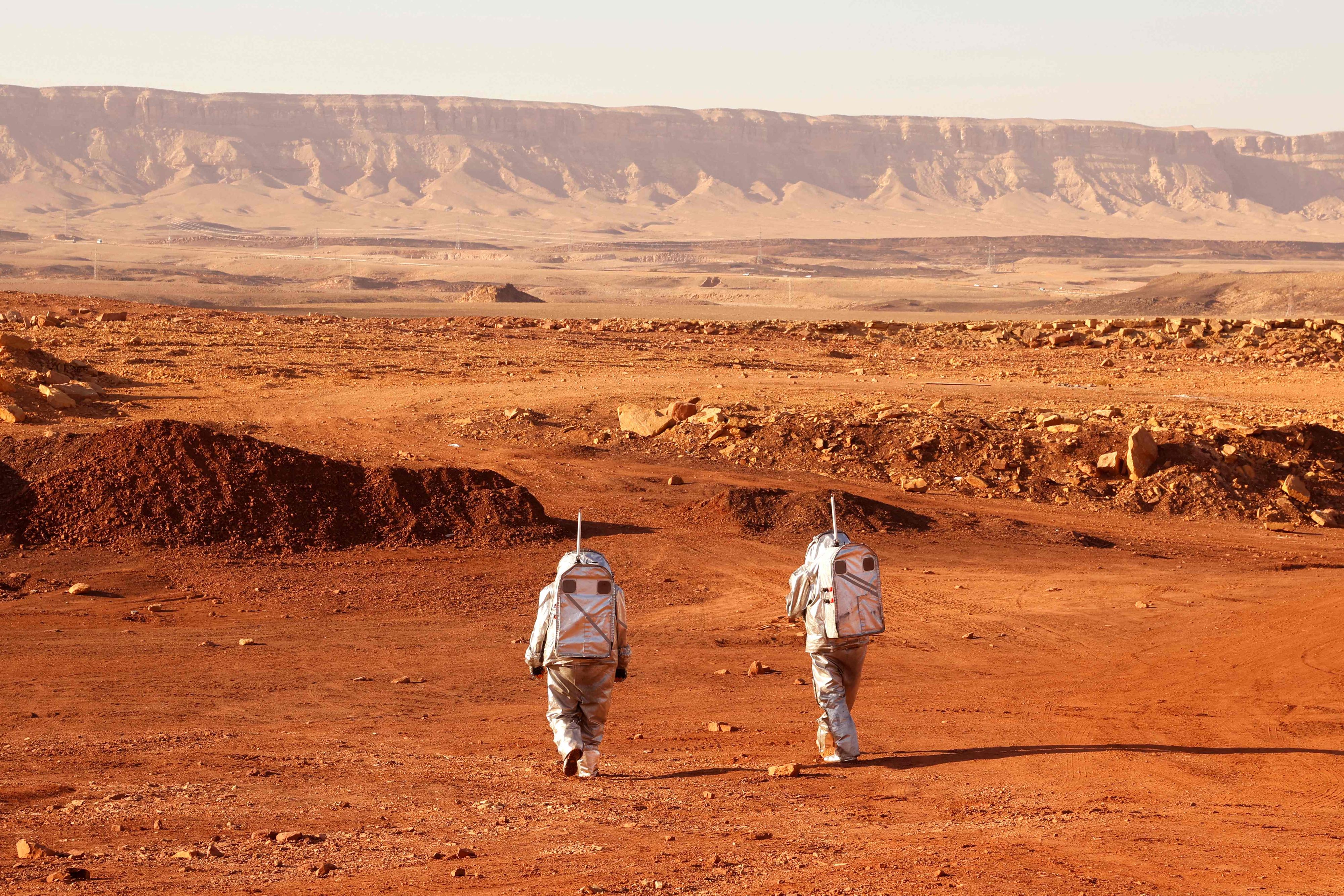 Download von www.picturedesk.com am 03.01.2022 (12:32).  TOPSHOT - A couple of astronauts from a team from Europe and Israel walk in spacesuits during a training mission for planet Mars at a site that simulates an off-site station at the Ramon Crater in Mitzpe Ramon in Israel's southern Negev desert on October 10, 2021. - Six astronauts from Portugal, Spain, Germany, the Netherlands, Austria, and Israel will be cut off from the world for a month, from October 4-31, only able leave their habitat in spacesuits as if they were on Mars. Their mission, the AMADEE-20 Mars simulation, will be carried out in a Martian terrestrial analog and directed by a dedicated Mission Support Center in Austria, to conduct experiments ahead of future human and robotic Mars exploration missions. (Photo by JACK GUEZ / AFP) - 20211010_PD11635 - Rechteinfo: Rights Managed (RM) Nur für redaktionelle Nutzung! Werbliche Nutzung erfordert Freigabe: bitte schicken Sie uns eine Anfrage.