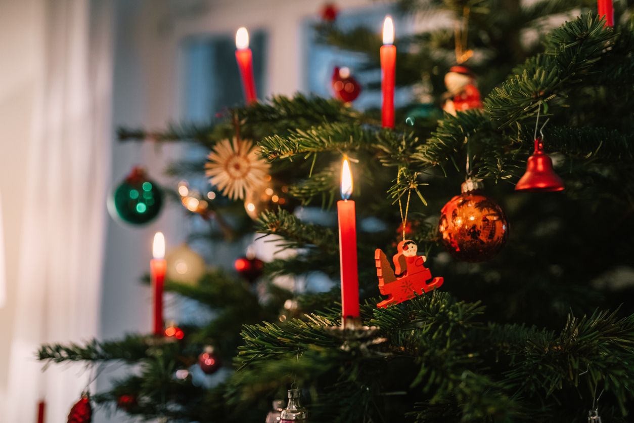 red candles burning on traditional german christmas tree at christmas eve