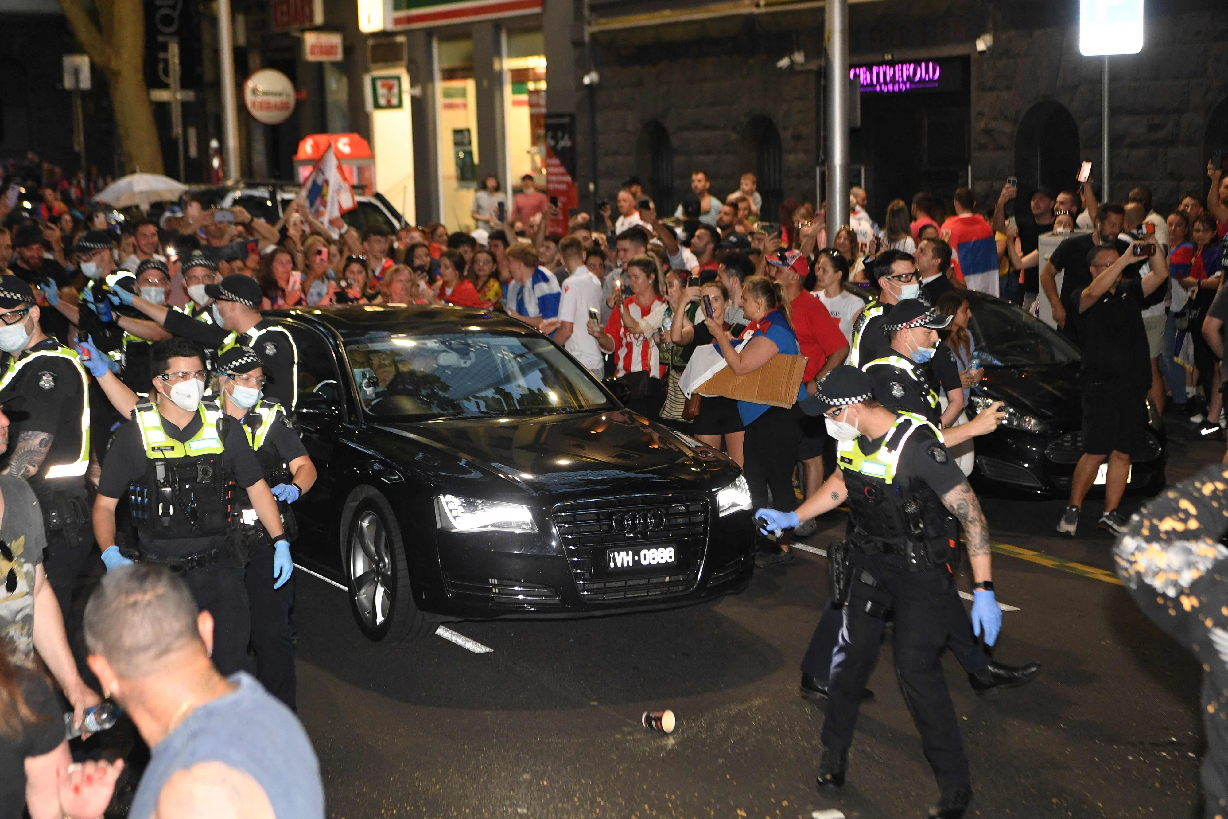 Novak Djokovic wird von der Polizei durch die Fan-Massen eskortiert.