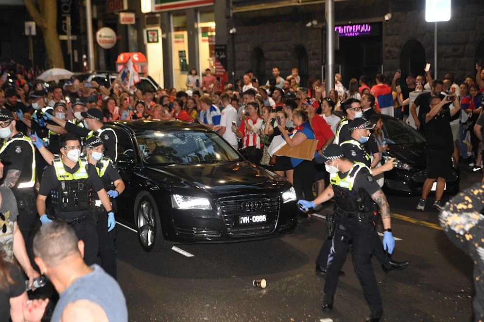 Novak Djokovic wird von der Polizei durch die Fan-Massen eskortiert.