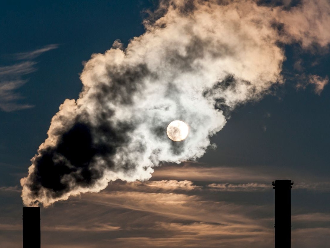 Die Abgase eines Heizkraftwerkes werden von der Sonne durchleuchtet