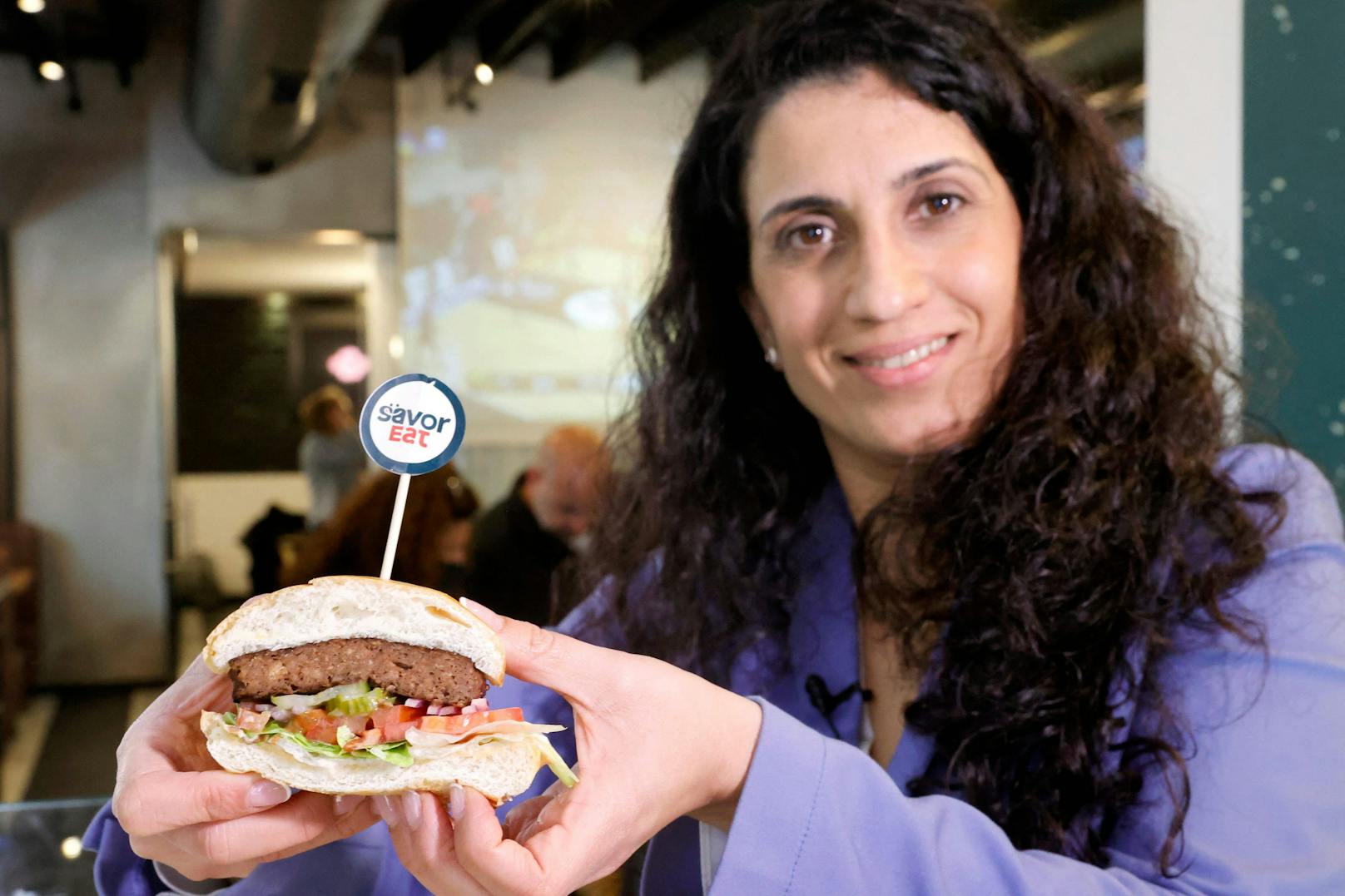 Racheli Vizman, CEO von SavorEat, hält eines der&nbsp;vegane, individualisierte Burger-Patty aus ihrem 3D-Drucker in die Kamera – sieht gar nicht schlecht aus.