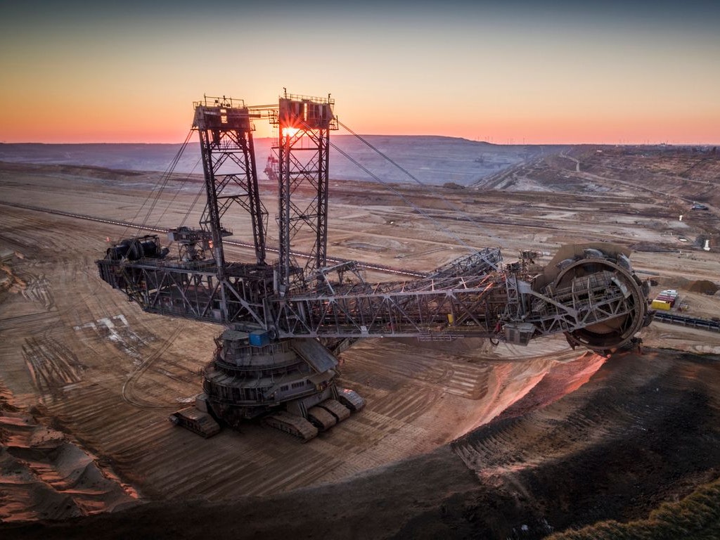 Aerial shot of a giant open pit lignite mine Hambach in Germany. Large bucket excavator mining machinery. Moody light at sunset.