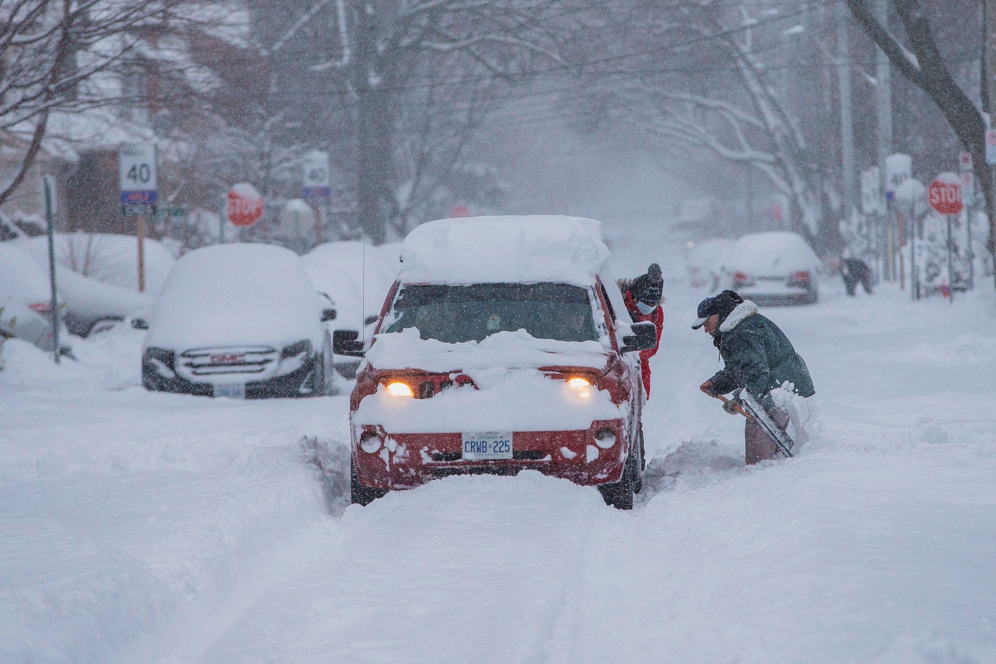 In Hamilton, Ontario, versuchen diese Menschen ihren Wagen aus den Schneemassen zu befreien.