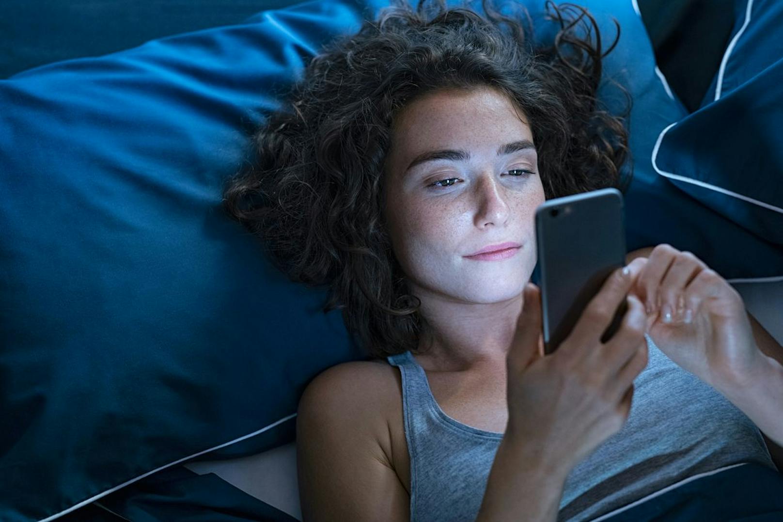 Lege dein Handy nicht nur kurz vor dem Schlaf auf die Seite. Verabschiede dich deshalb mindestens 60 Minuten vor dem Schlafengehen von deinen Smart-Geräten.
